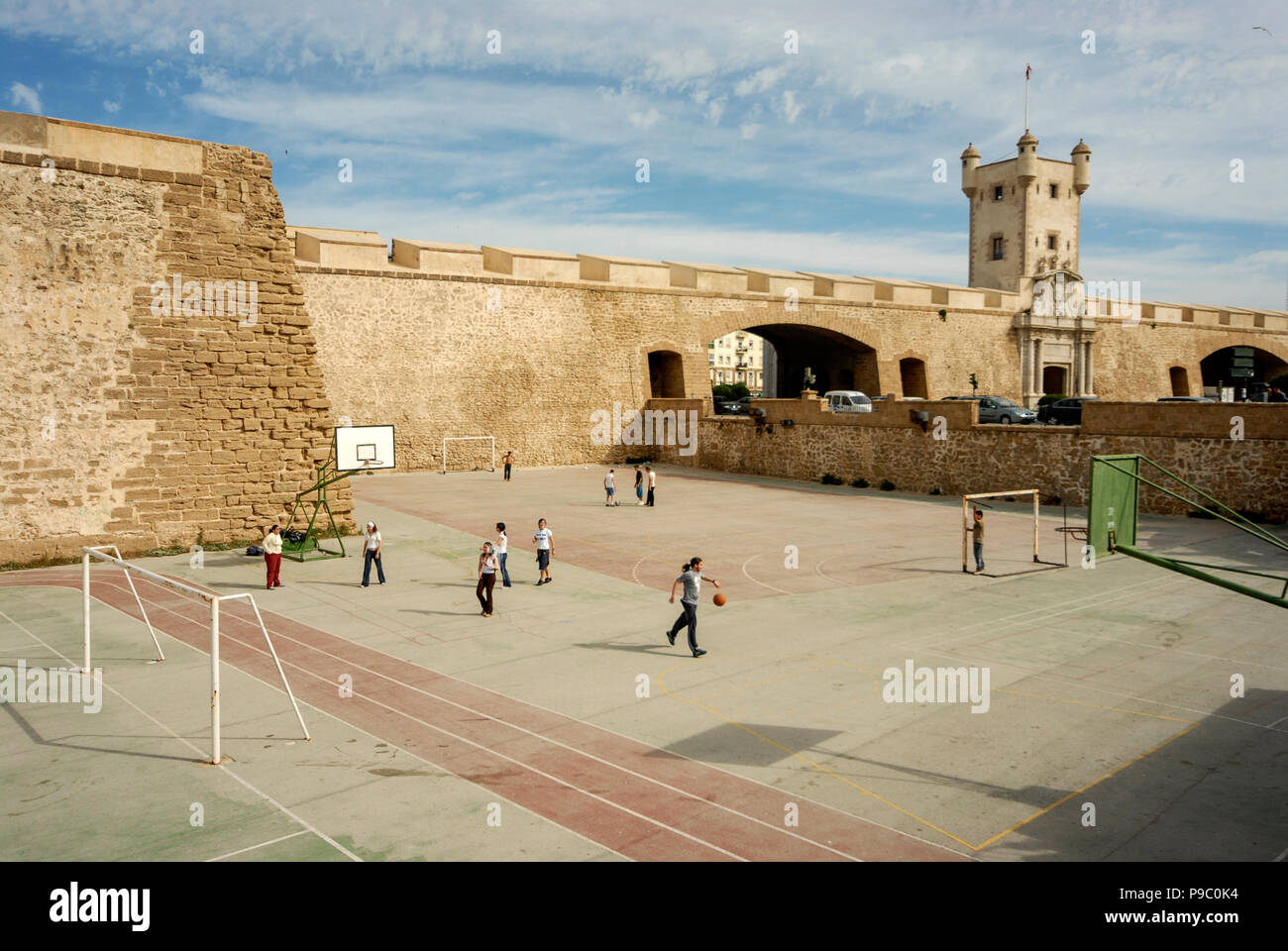 Children playing in a small sports playing area near the Puerta de Tierra, (Land gate) and ancient city wall in Cadiz, Andalusia, southern Spain   The Stock Photo