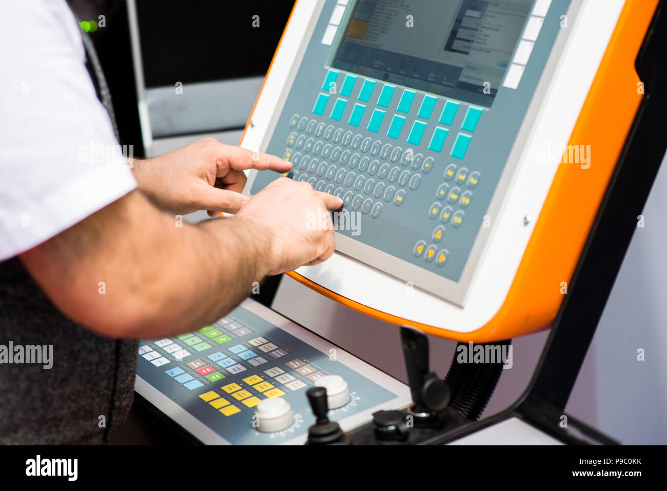 Man working on a keyboard of a console for controlling an industrial ...