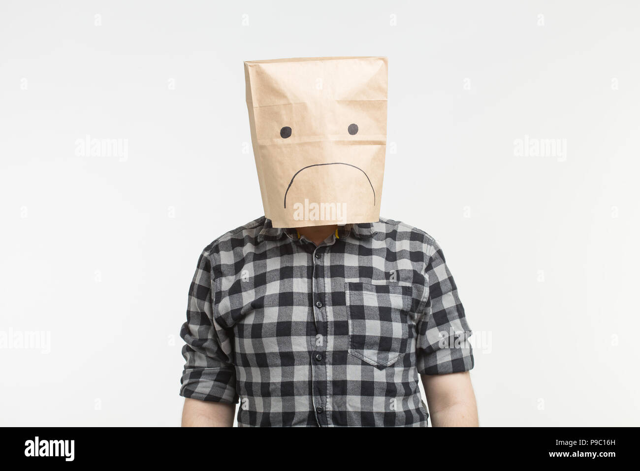 unhappy-man-with-sad-emoticon-in-front-of-paper-bag-on-his-head-on-white-background-P9C16H.jpg