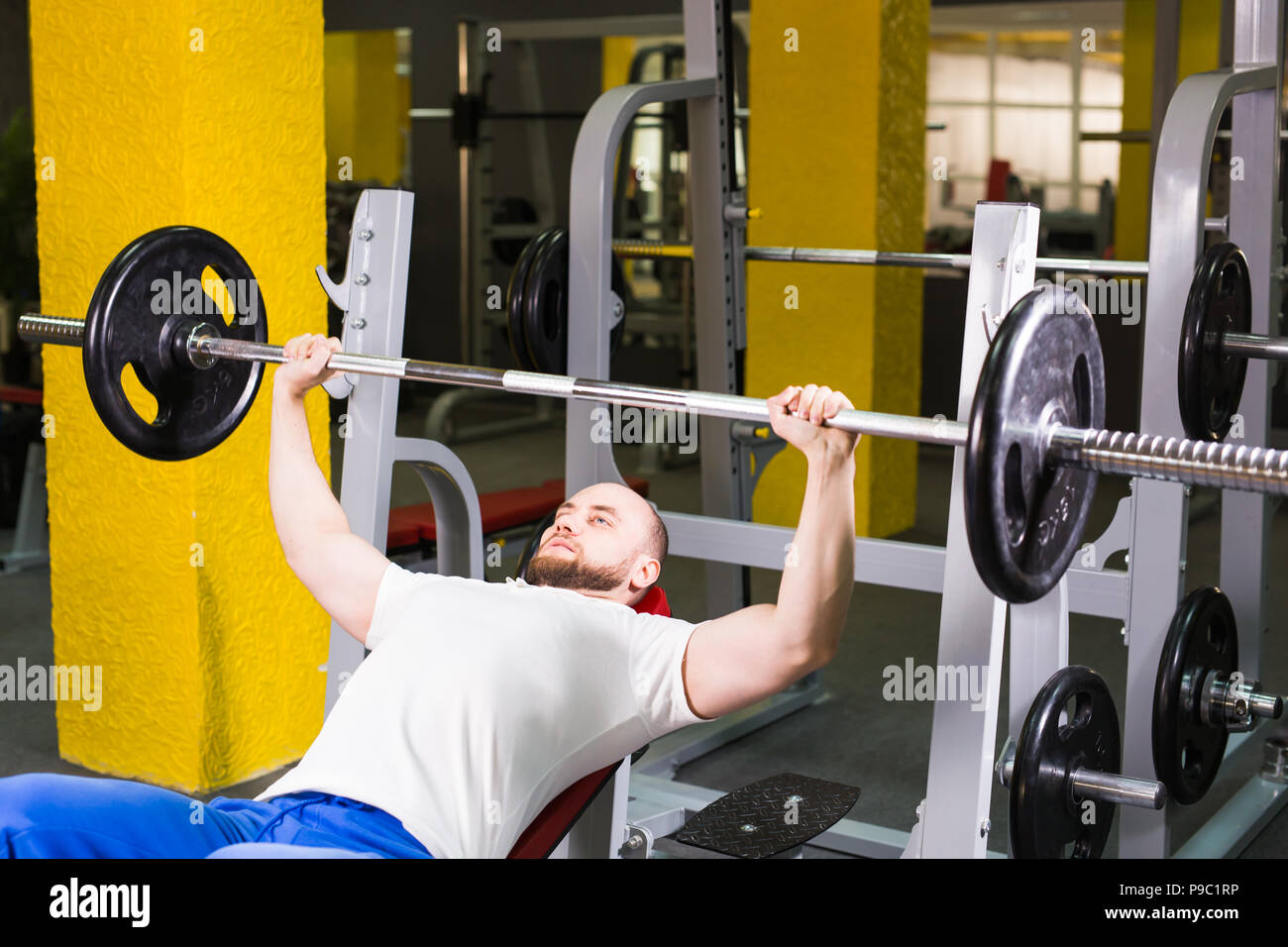 Sport, fitness, training and people concept - Muscular man doing heavy ...
