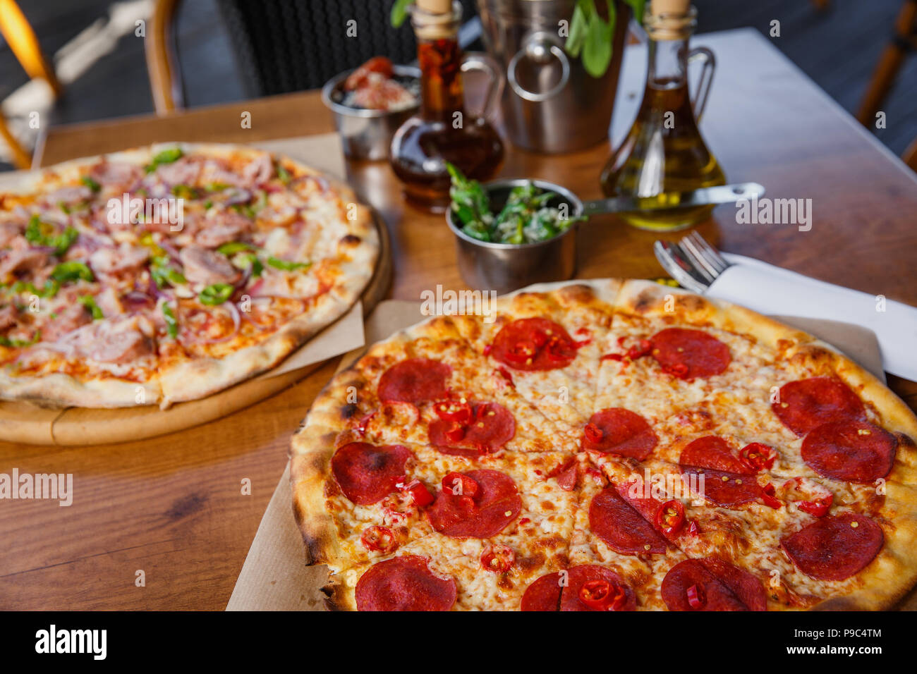 Hot delicious pepperoni pizza on wooden restaurant table. Stock Photo