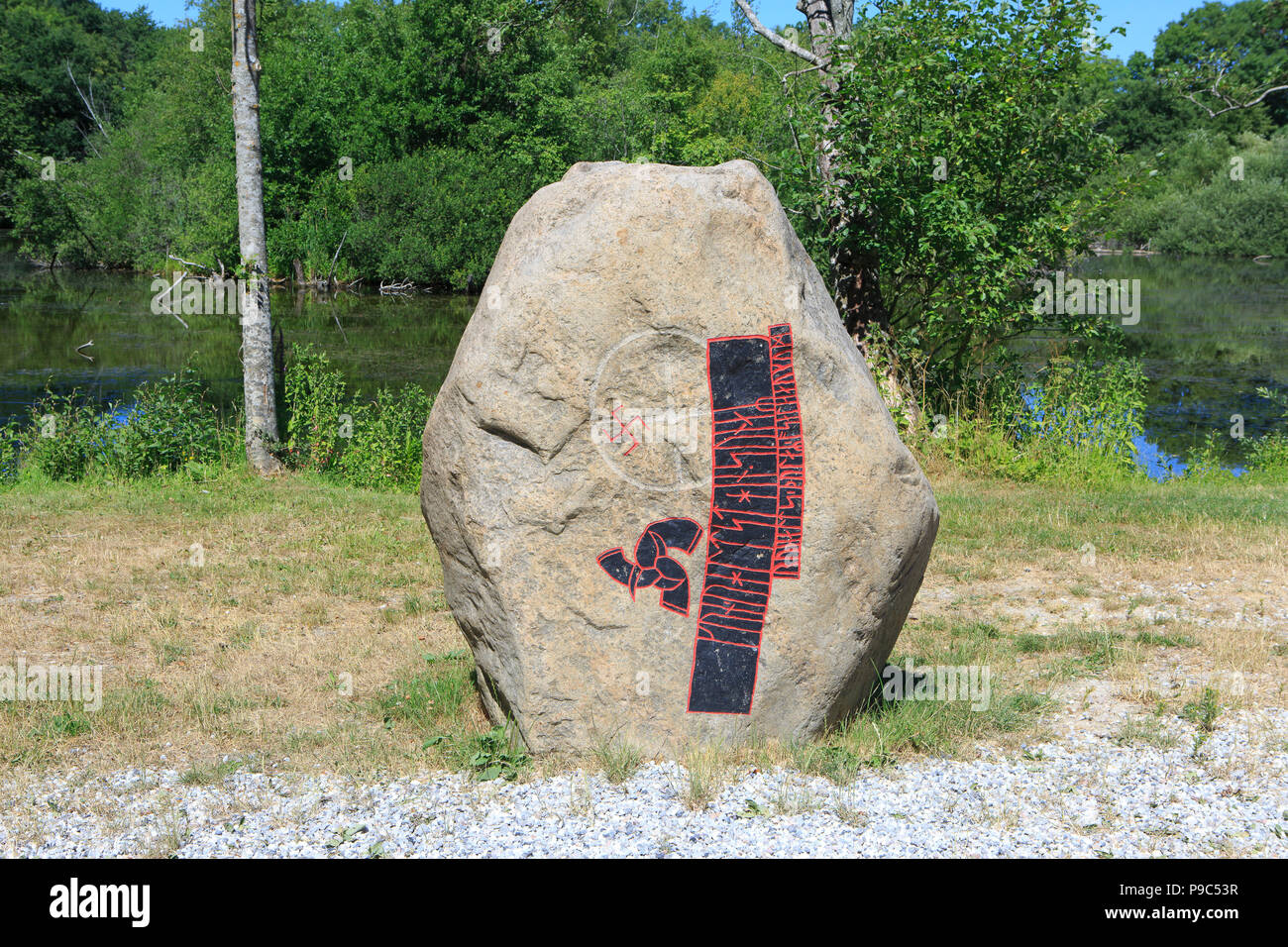 A sacred Neolithic-Iron Age runestone with a gammadion (swastika) and tiskelion (triple spiral) at The Land of Legends in Lejre, Denmark Stock Photo