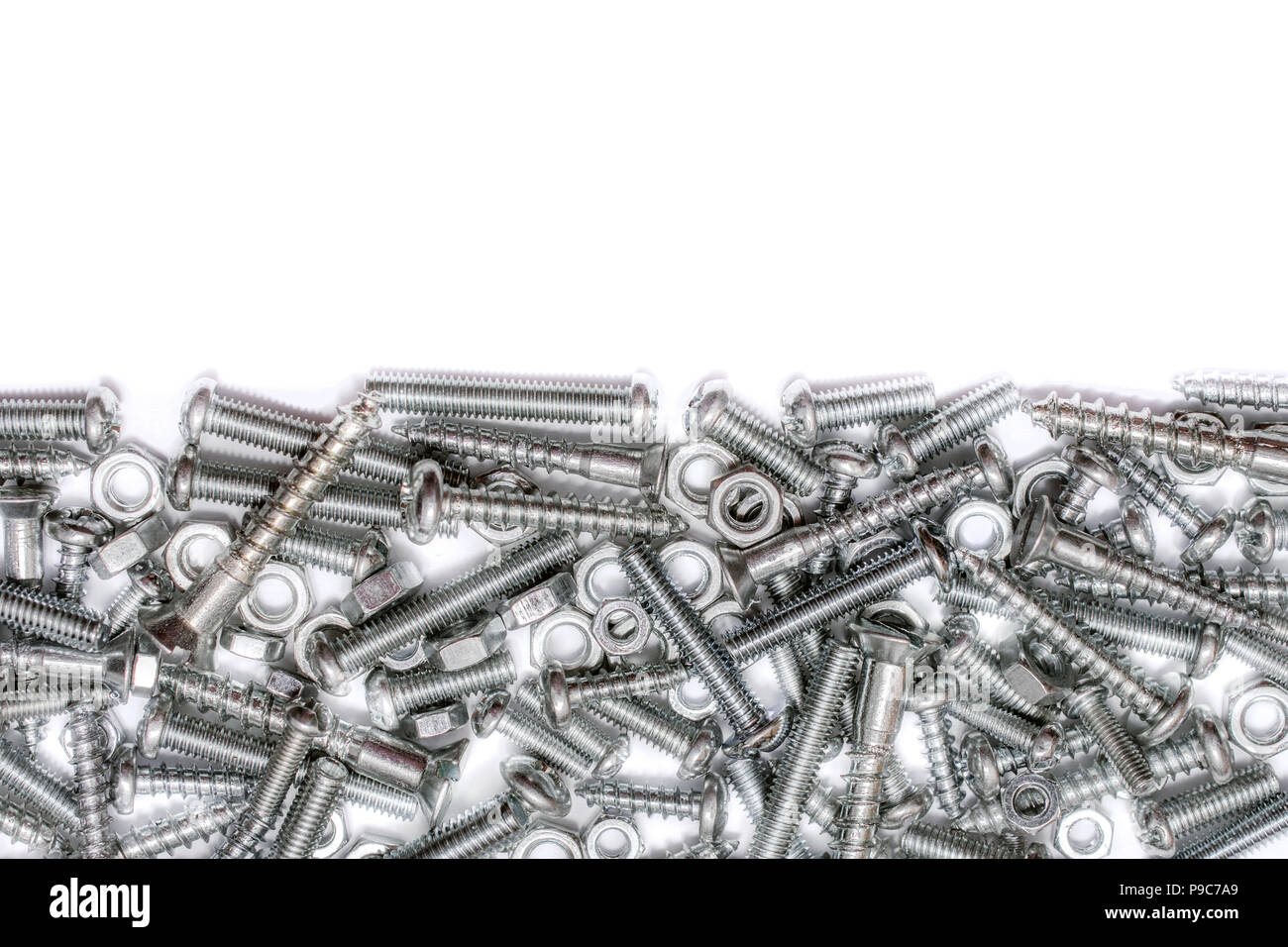 Big Collection Of Iron Screws, Wood Screws and Bolts With Free Space In The Upper Half Stock Photo