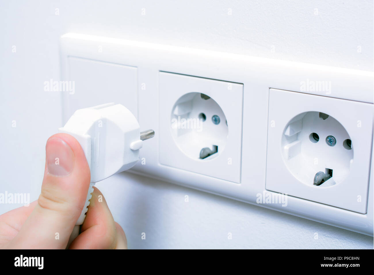 Male Hand Is Holding And Connecting An Electrical Plug In A Wall Socket Stock Photo Alamy