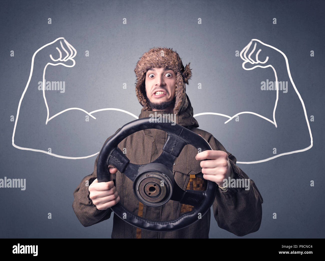Young man holding black steering wheel with muscly arms drawn next to