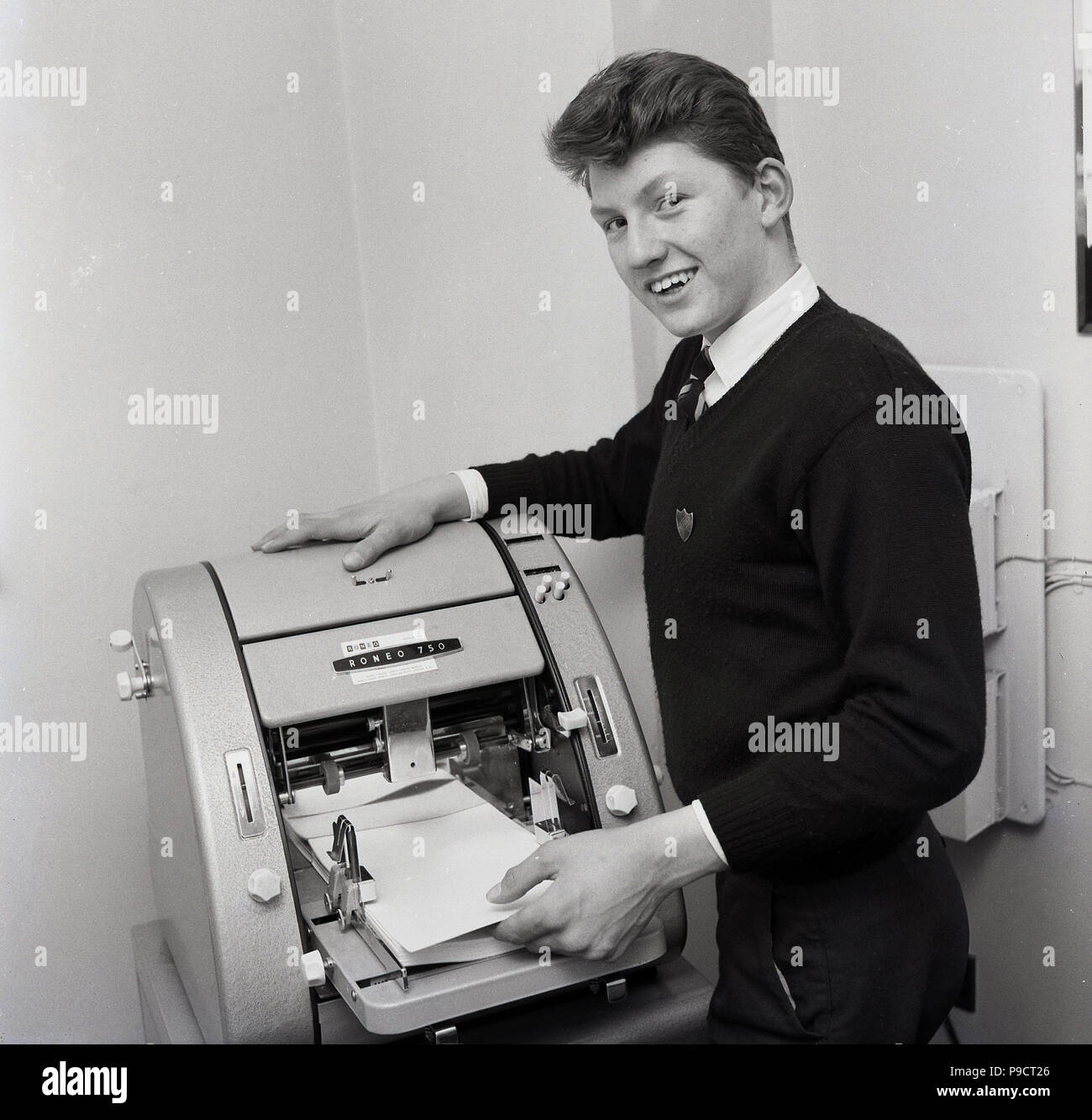 1960s, historical, a young man at an office printing machine of the era, a Reneo 750. Stock Photo