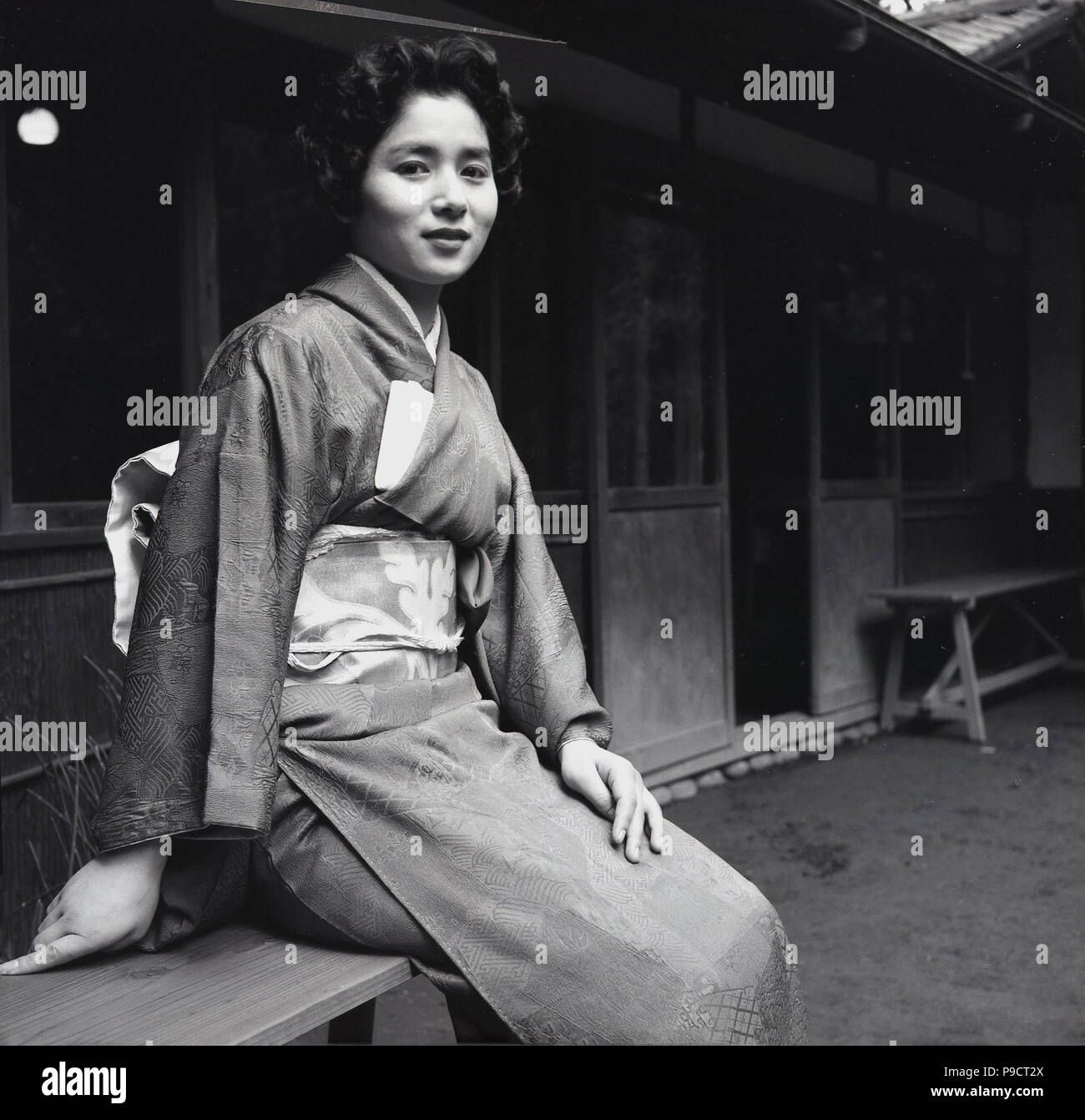 1950s, historical, a young woman sitting outside wearing a kimono ...
