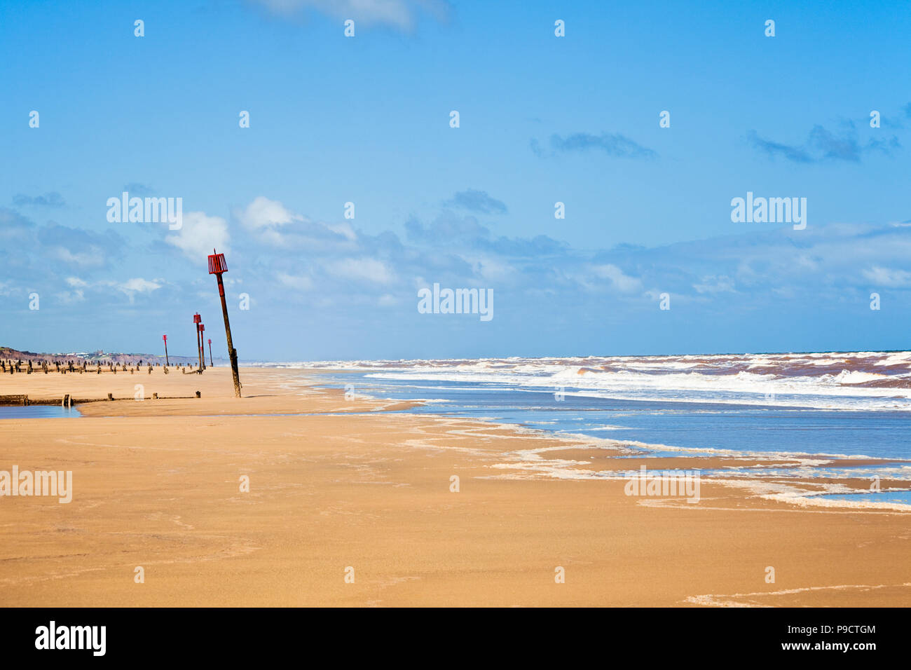 Groynes and beacons on the long sandy beach seafront at Withernsea, East Yorkshire, England, UK Stock Photo
