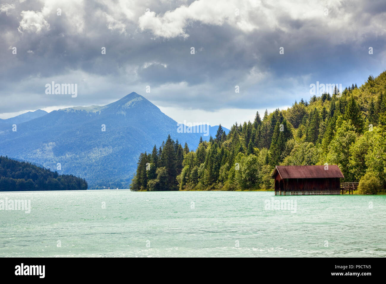 Wooden boat house on a lake overlooking mountains, Austria, Europe Stock Photo