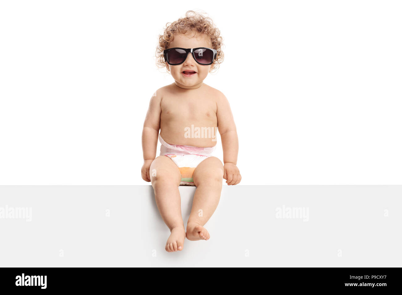 Baby boy wearing a pair of sunglasses sitting on a panel isolated on white background Stock Photo