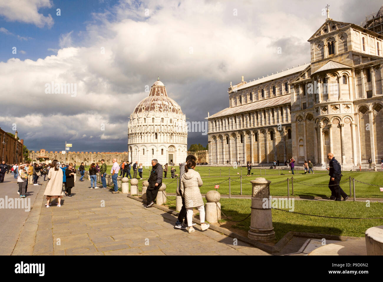 The Pisa Baptistery of St. John and Pisa Cathedral. Grand marble-striped cathedral known for its ornate Romanesque bronze doors & carved 1300s pulpit. Stock Photo