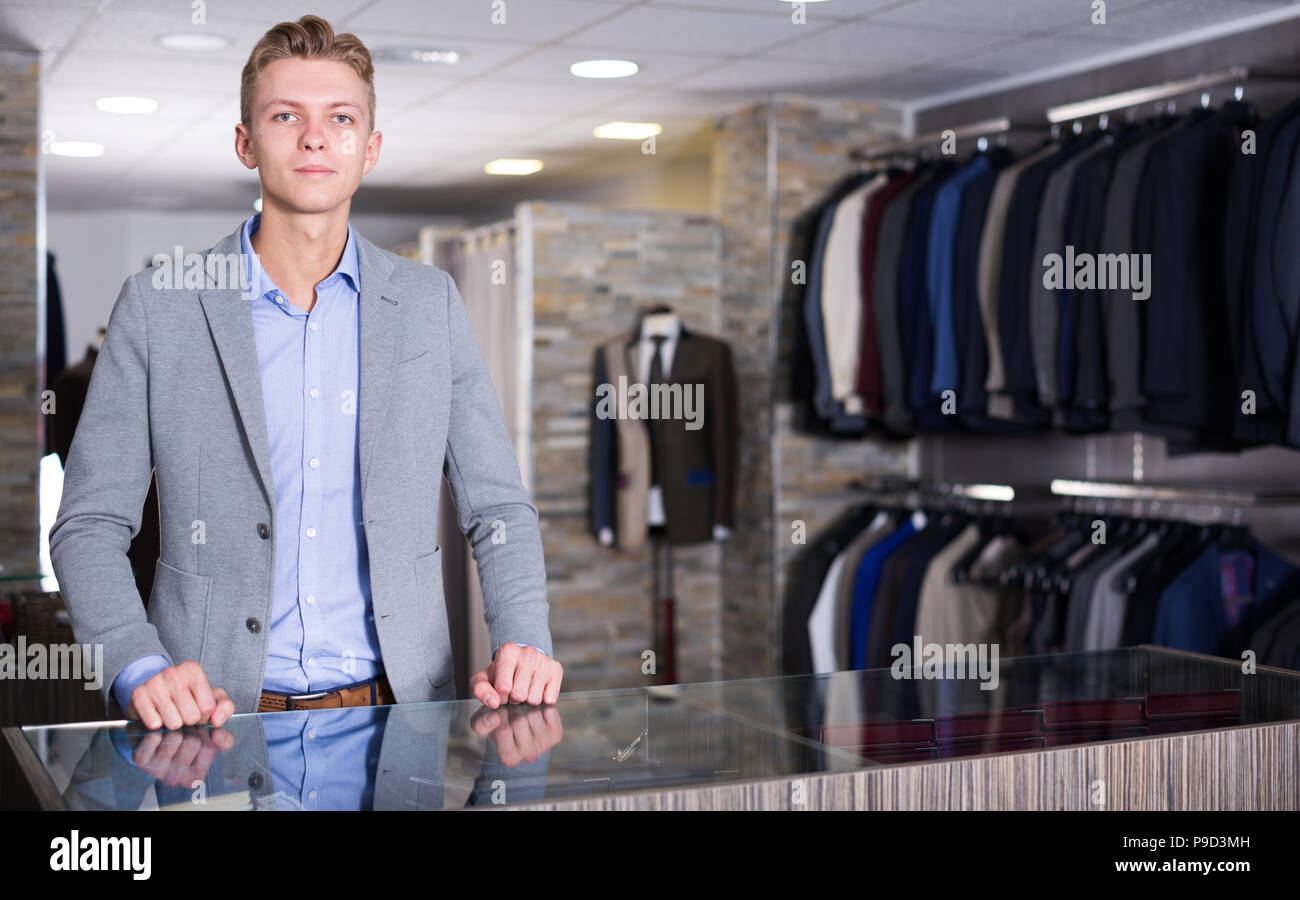 Male in business clothes seller standing in the dress shop Stock Photo