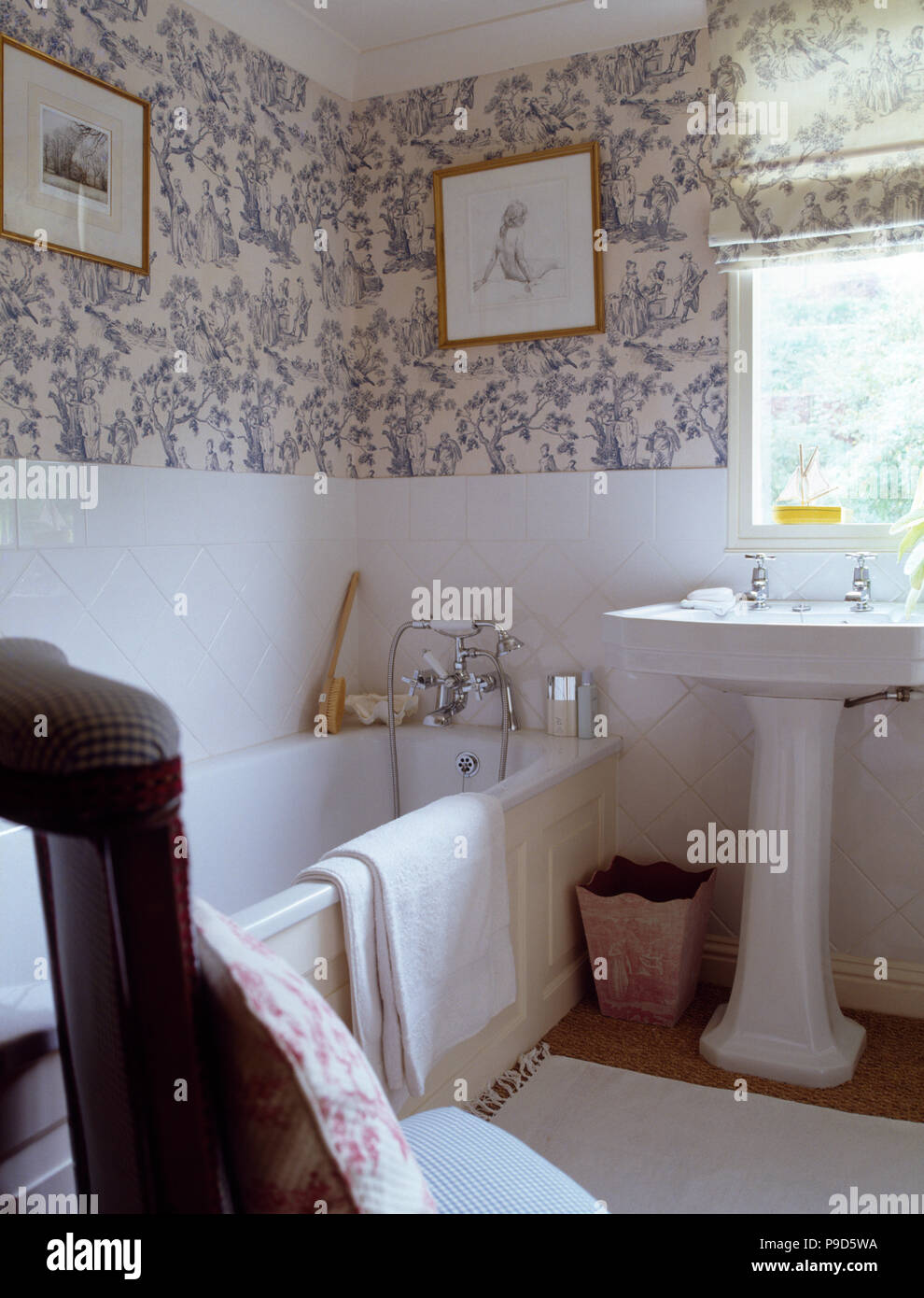 Toile de Jouy wallpaper in bathroom with a white pedestal basin below the window Stock Photo