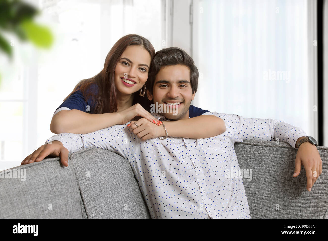 Portrait of a young woman embracing young man from behind Stock Photo ...
