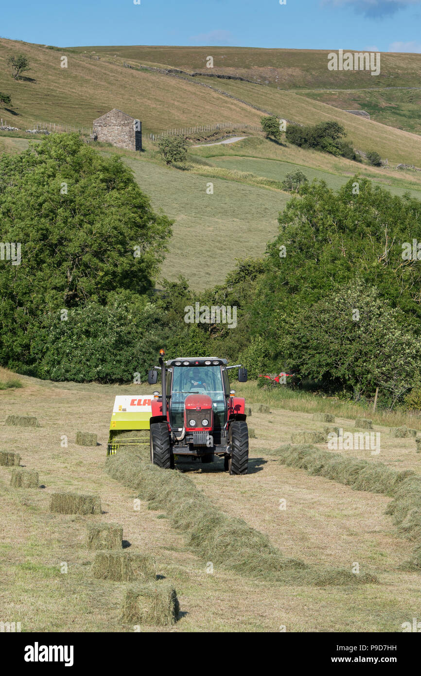 Farmer in Swaledale, North Yorkshire making bales of hay, using a