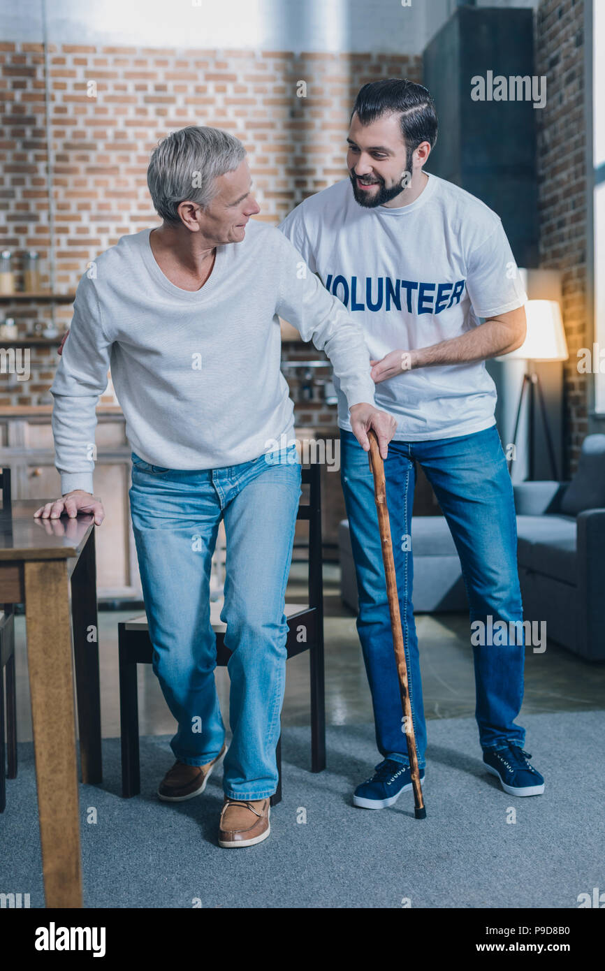 Kind alert man helping an aged man Stock Photo