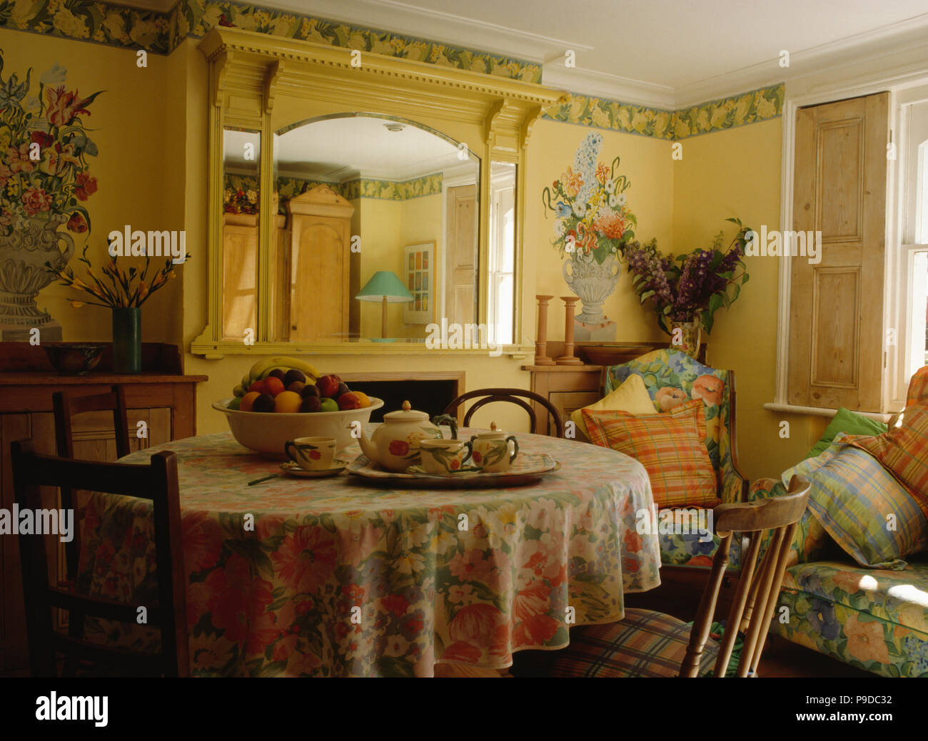 Flower murals on the walls of pastel yellow dining room with floral