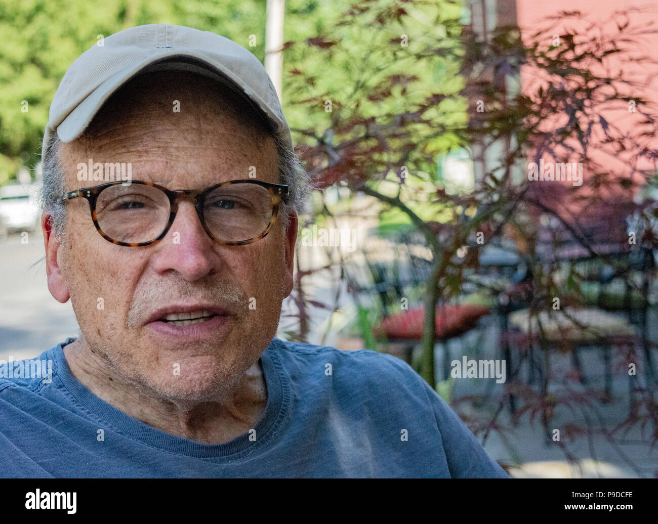 Older man conversing wearing a cap and glasses Stock Photo