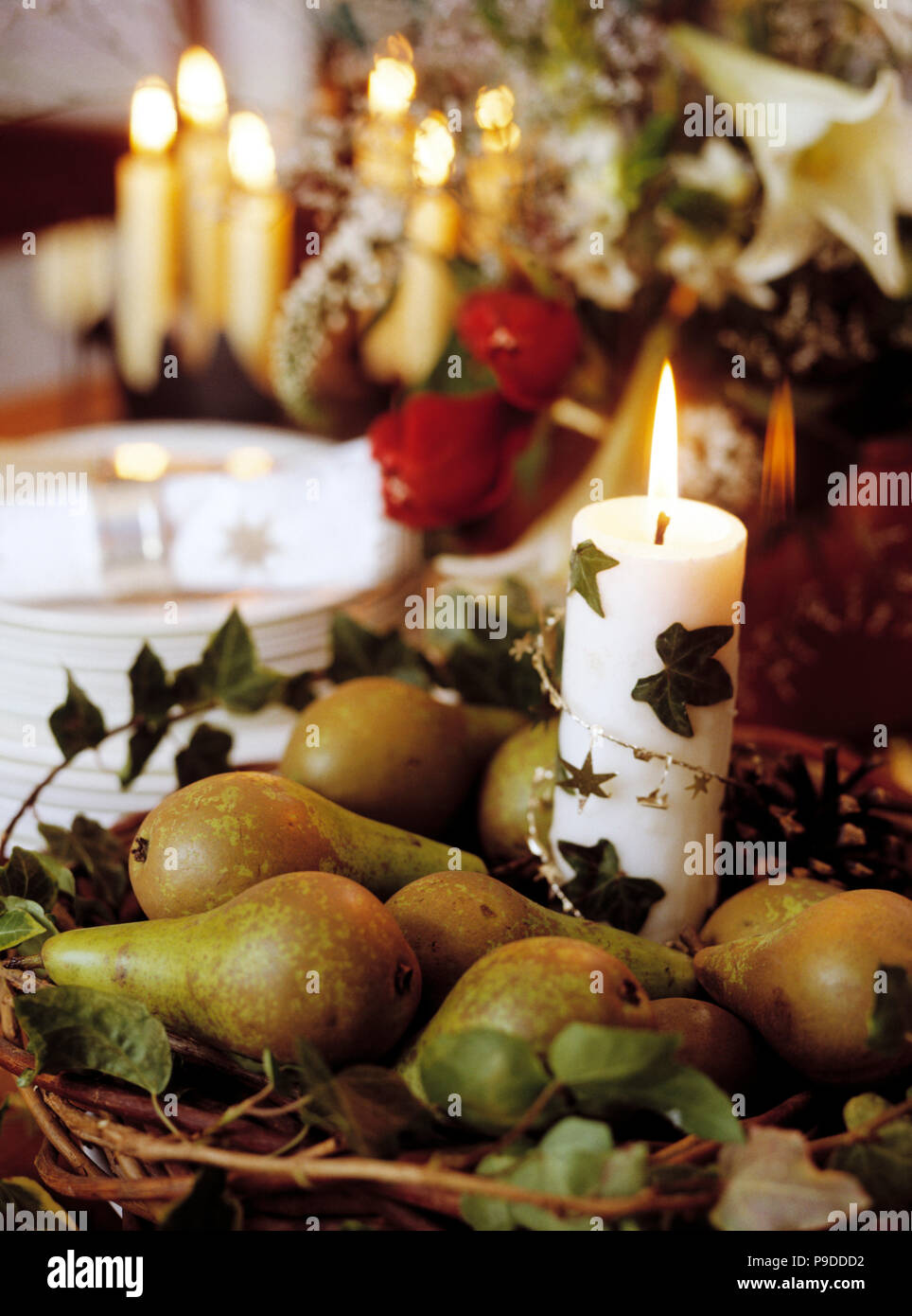 Close-up of simple Christmas decoration of white candle in basket of ...