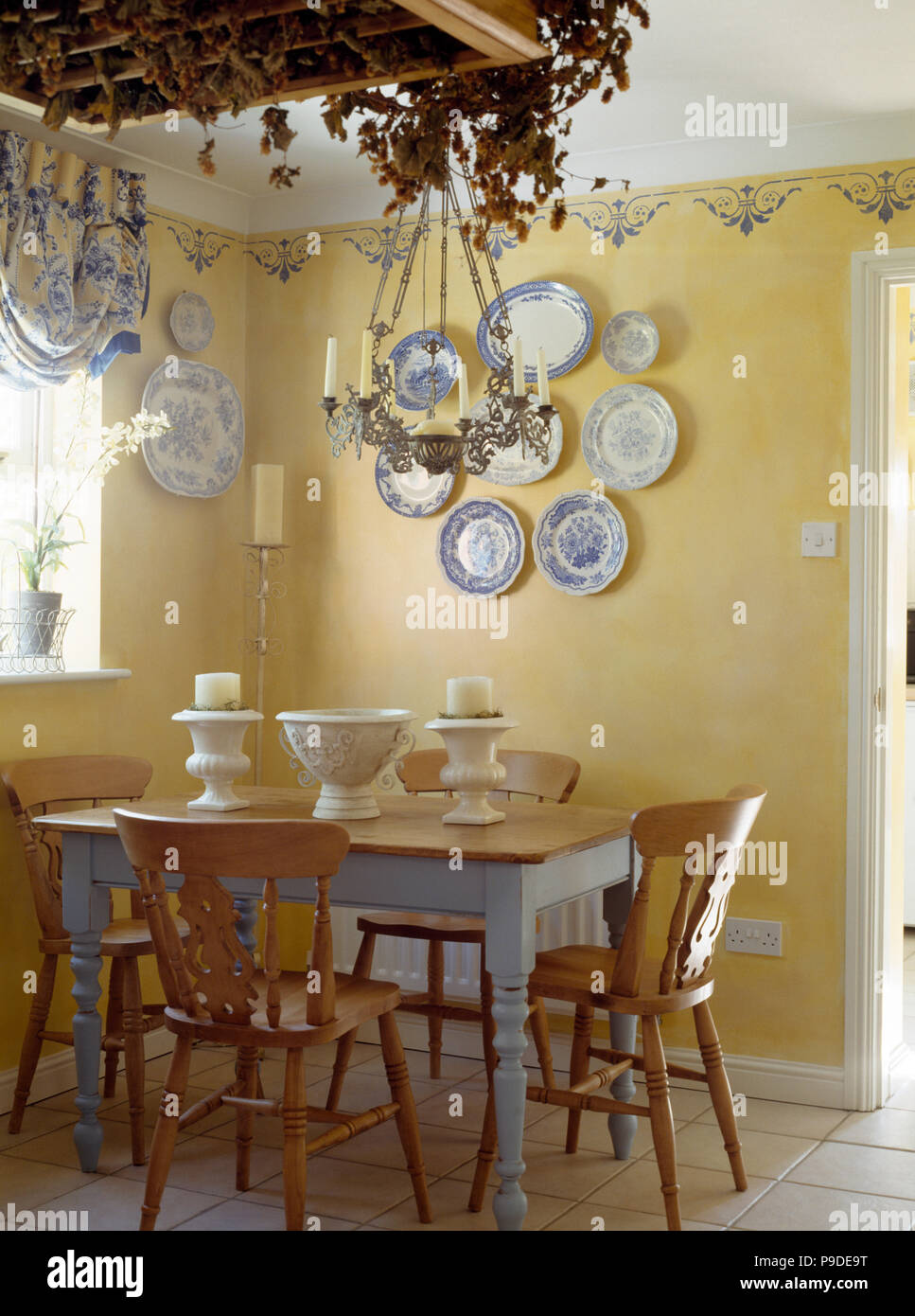 Pine Chairs And Painted Table In A Cottage Dining Room With A