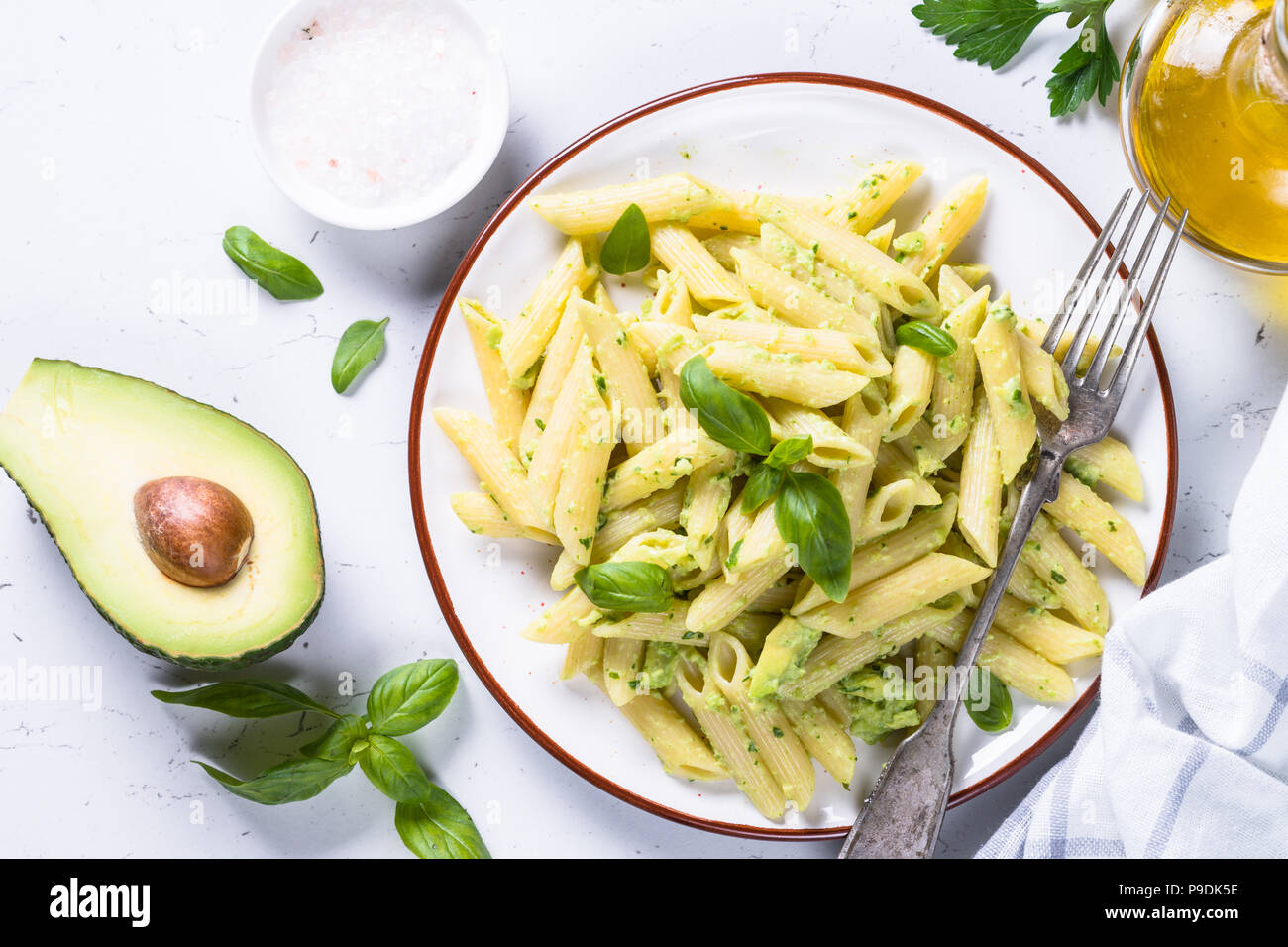 Vegan pasta penne with avocado and basil. Vegetarian food. Top view on