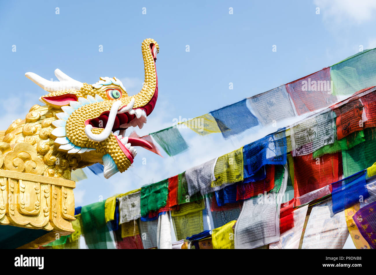 Golden dragon head statue with prayer flags in Boudhanath, Kathmandu, Nepal Stock Photo