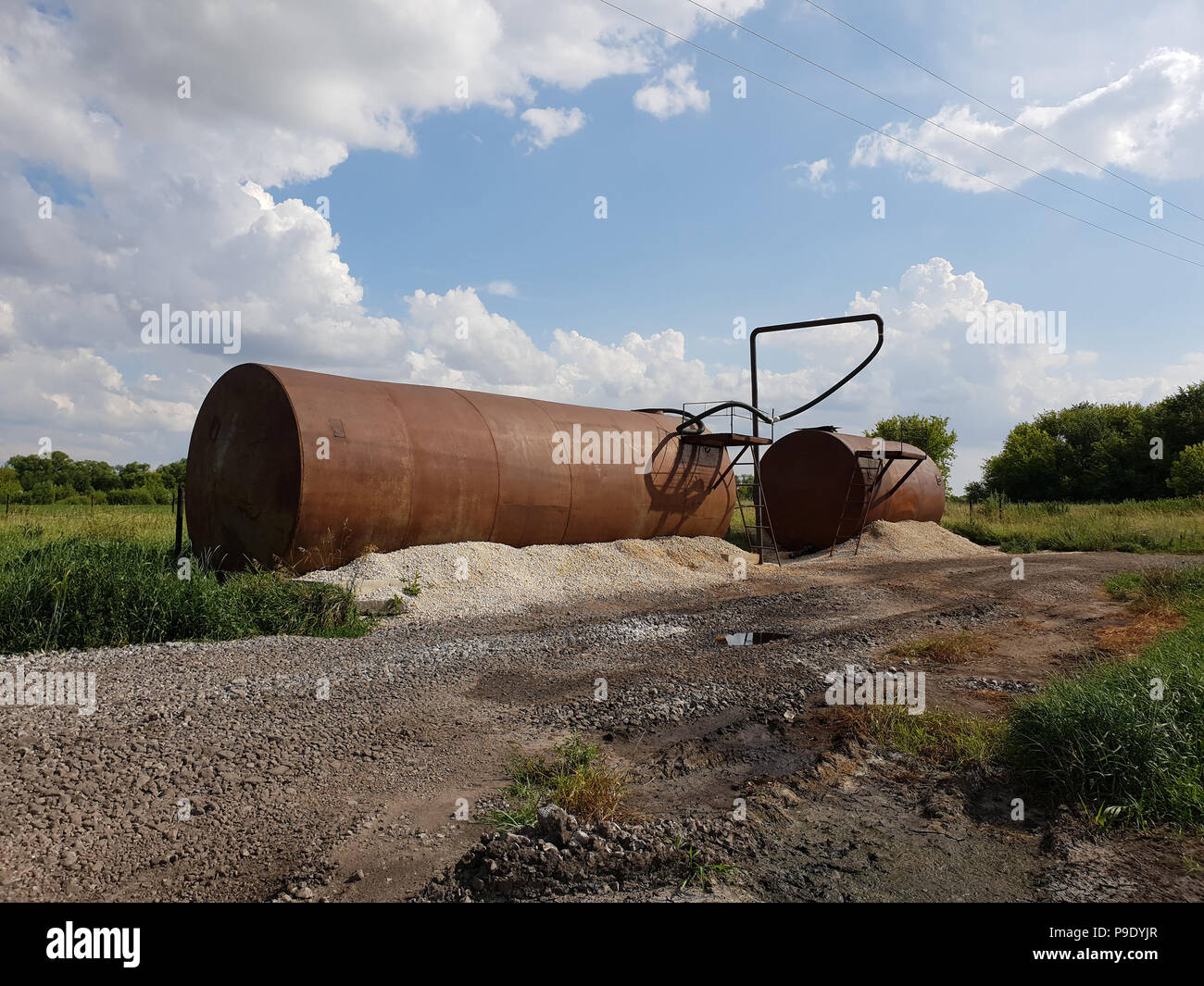 Tanks with liquid fertilizers on the outskirts of the field. Stock Photo