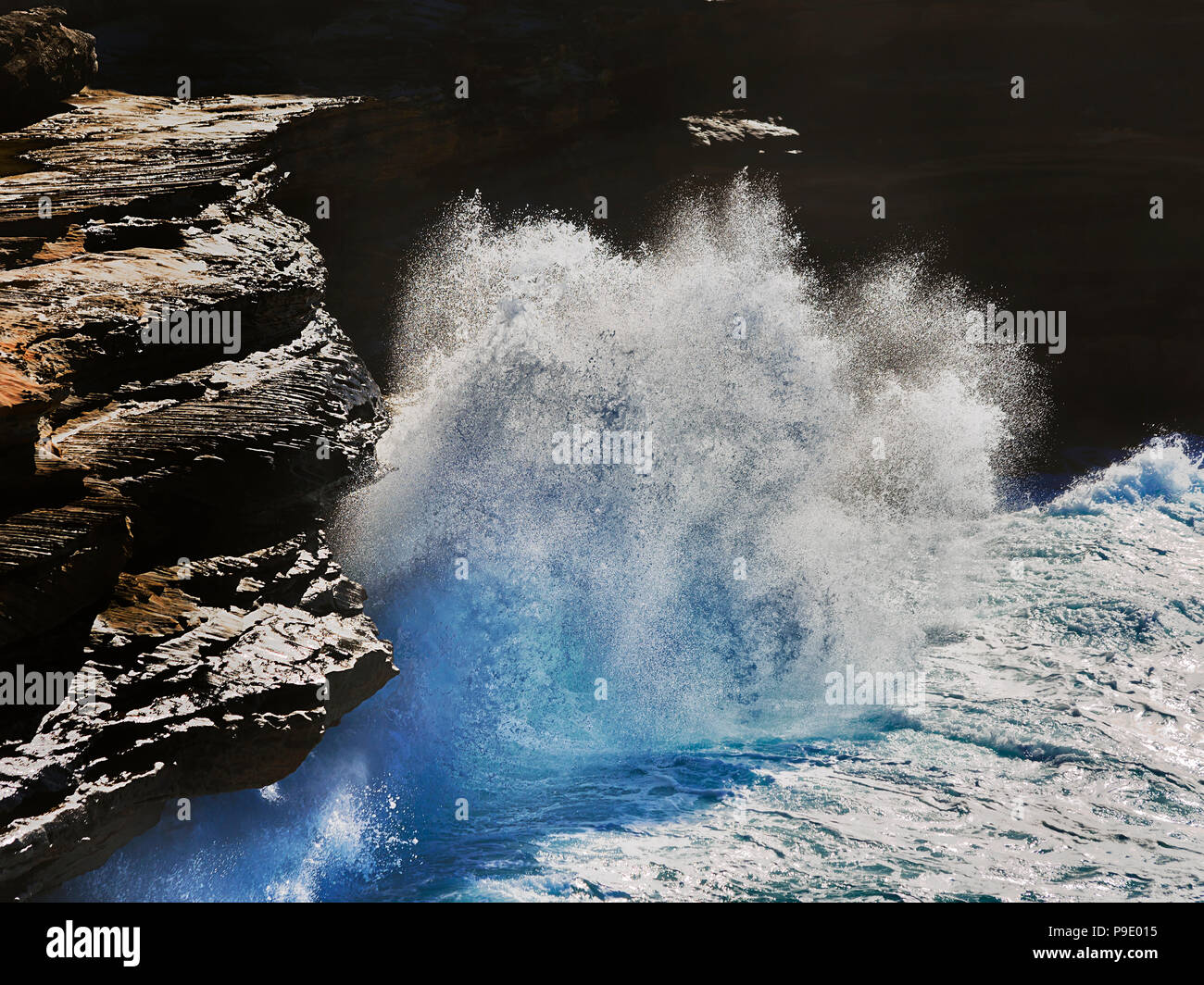 Mightly powerful wave hits sandstone cliffs of Cape Solander coast of Sydney facing Pacific ocean in endless undermining of coast. Stock Photo