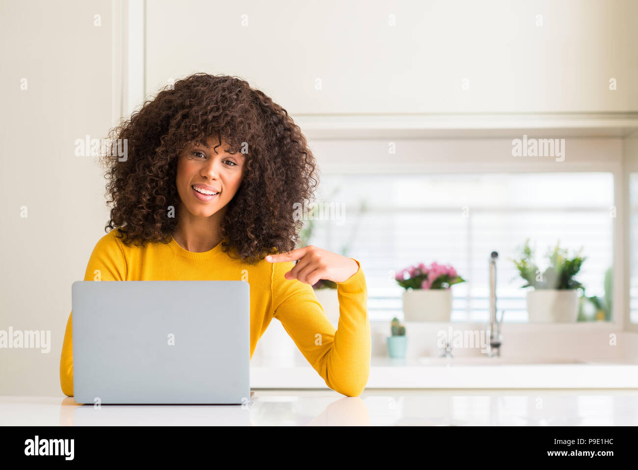 African american woman using computer laptop at kitchen very happy ...