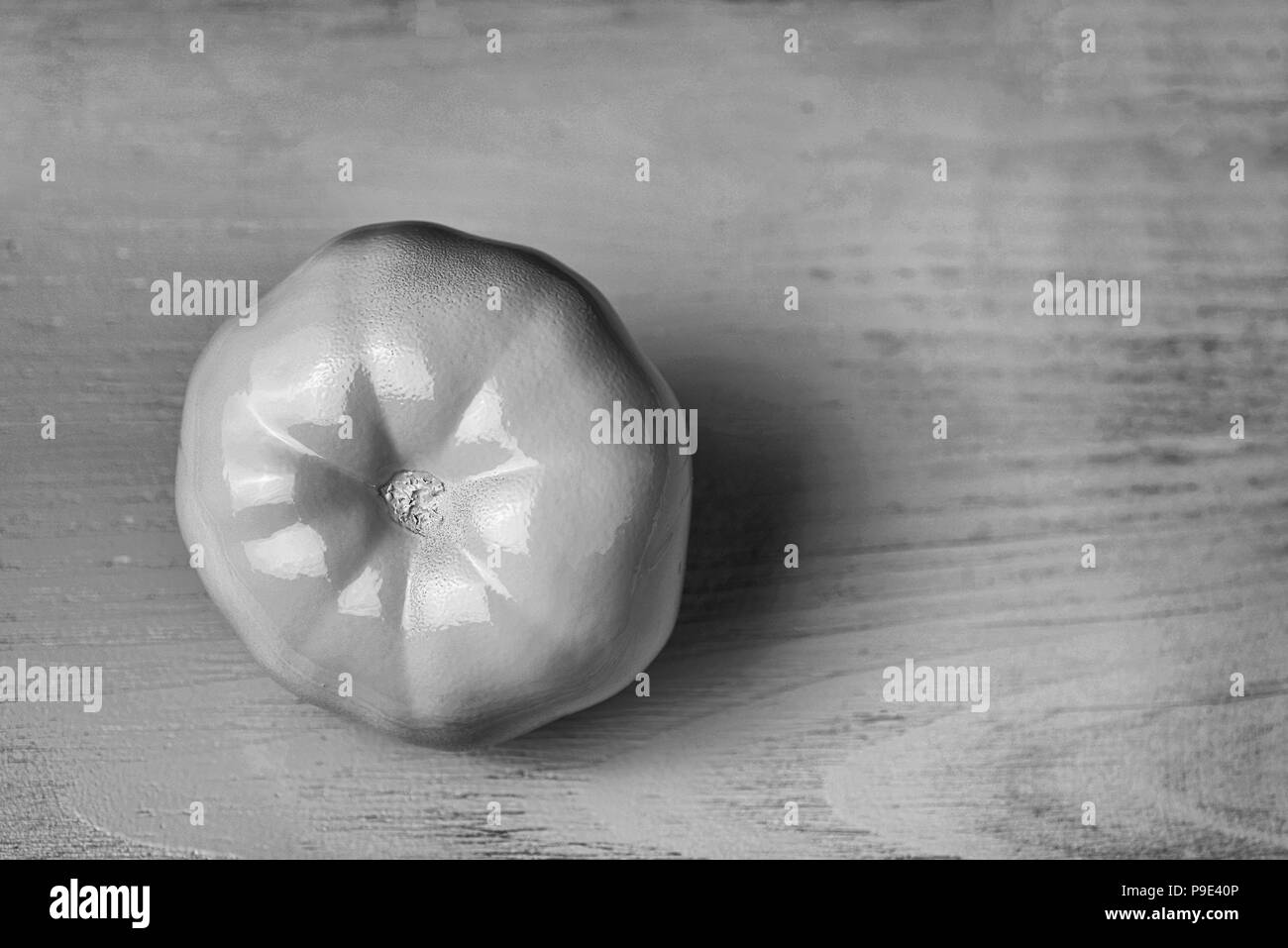 conceptual decoration of a cafe: white painted tomato on wooden background. Black and white vintage color designed vegetable Stock Photo