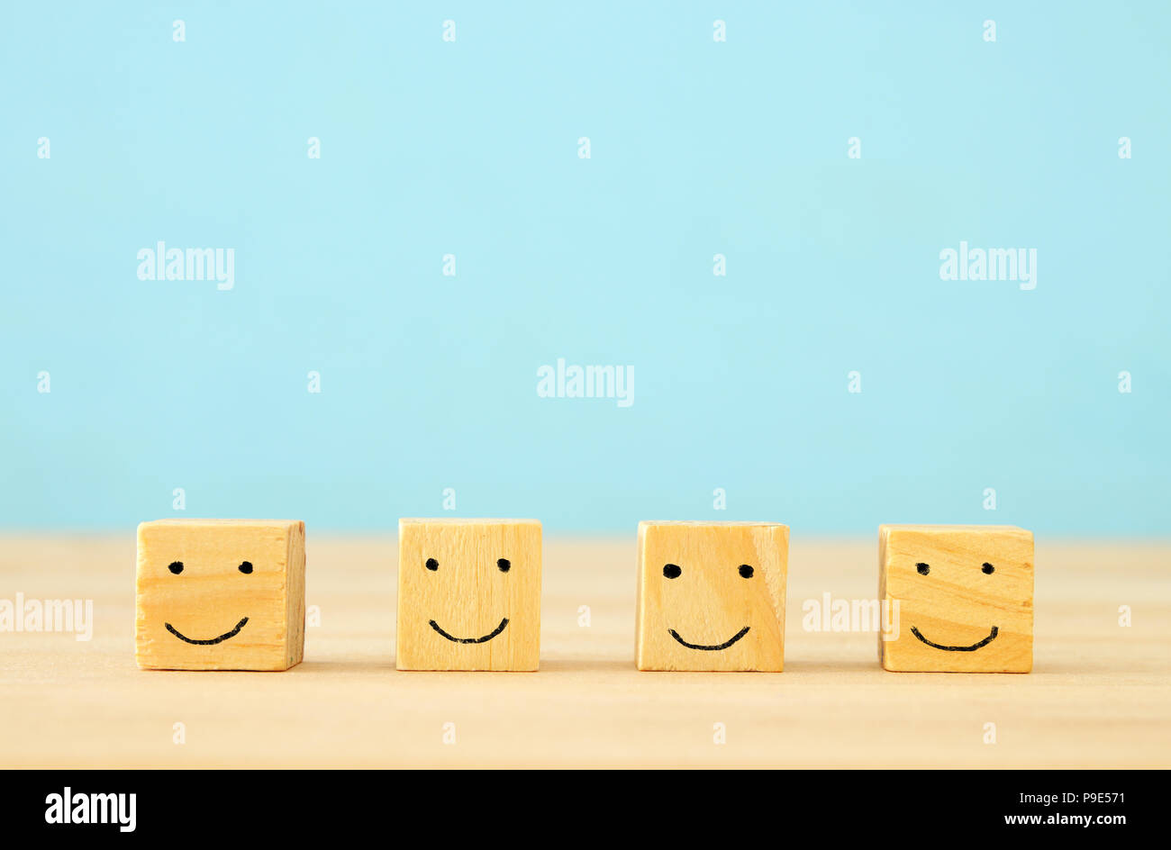 image of wooden blocks with smiling faces icons over table ,building a ...