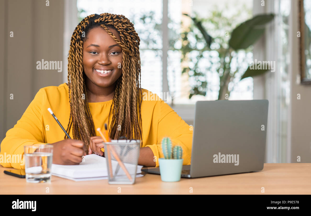 African american woman studying with laptop with a happy face standing ...