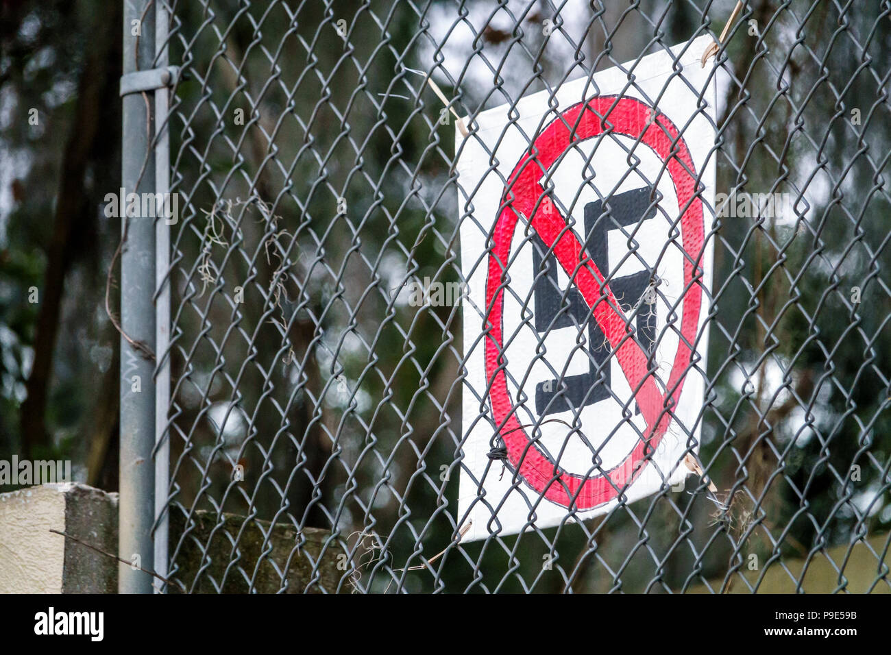 Gainesville Florida,anti-Nazi sign,Hakenkreuz swastika hate symbol,chain-link fence,FL171028180 Stock Photo