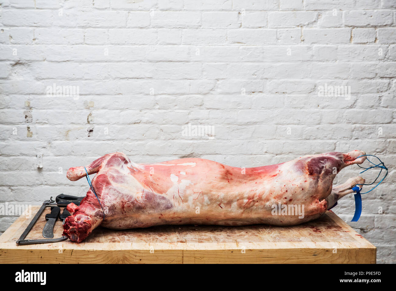 A whole lamb carcass on a butcher's block ready for butchering. Stock Photo