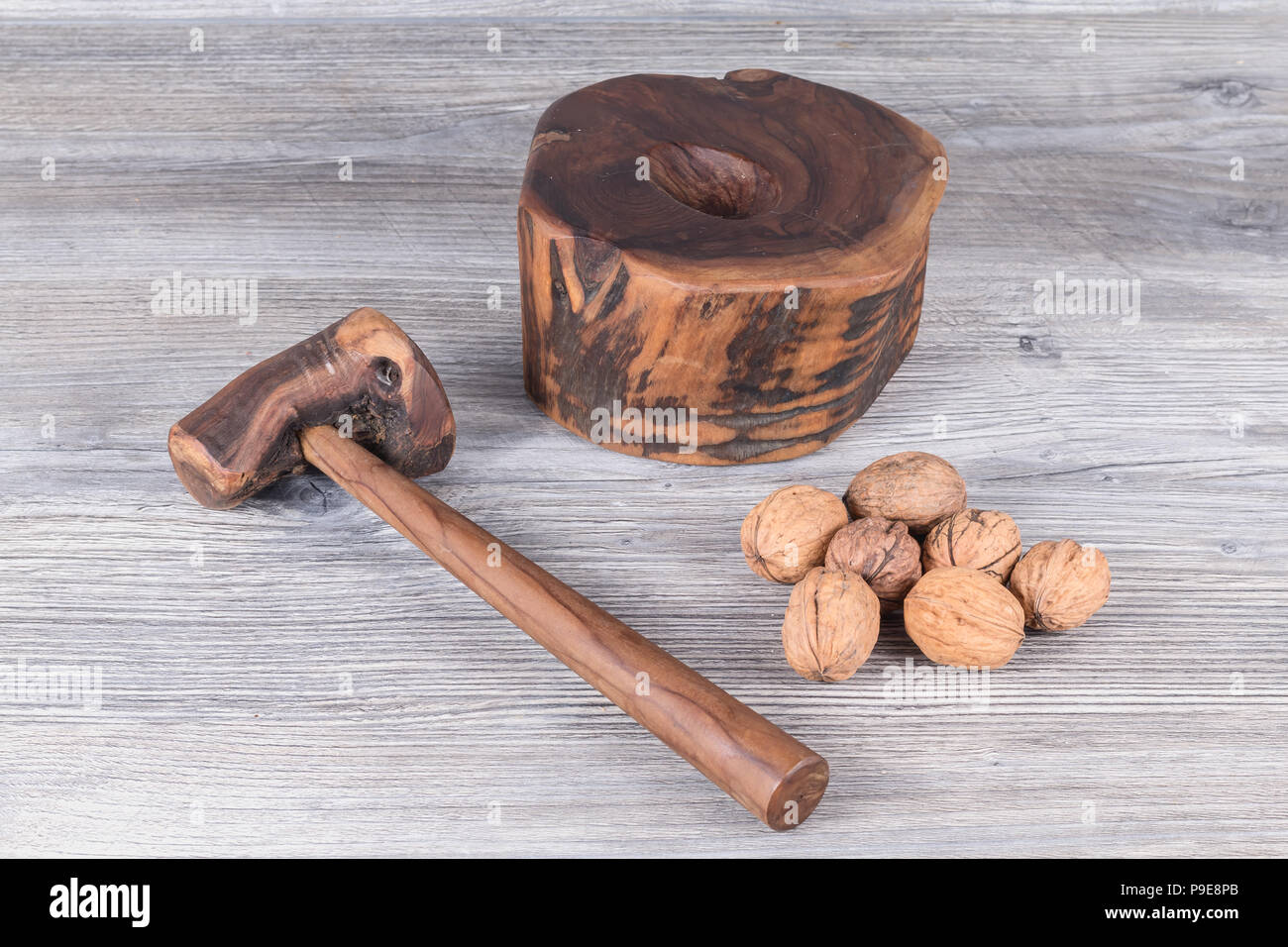 hammer nutcracker and walnuts on anthracite gray wood in background Stock Photo