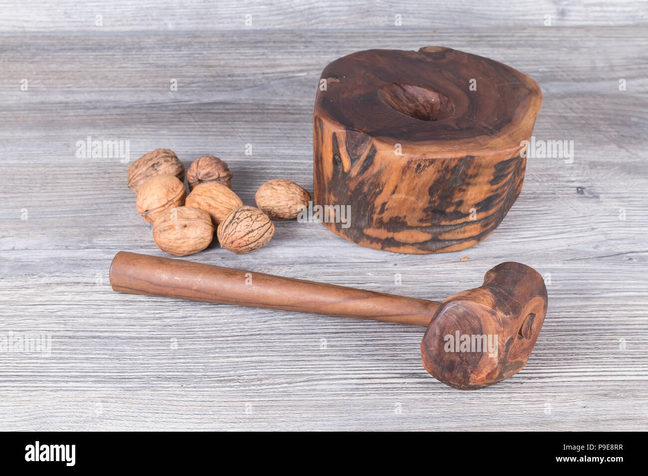 hammer nutcracker and walnuts on anthracite gray wood in background Stock Photo