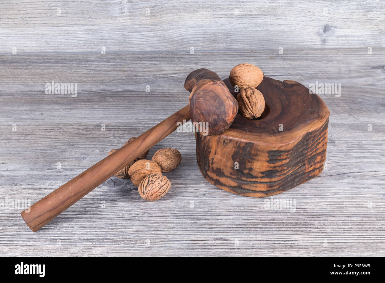 hammer nutcracker and walnuts on anthracite gray wood in background Stock Photo