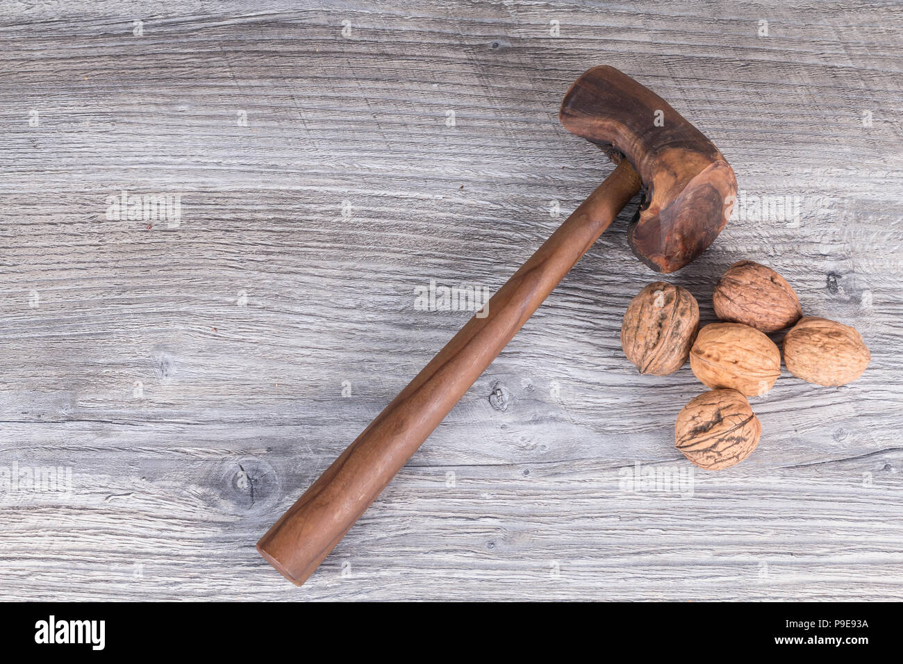 hammer nutcracker and walnuts on anthracite gray wood in background Stock Photo