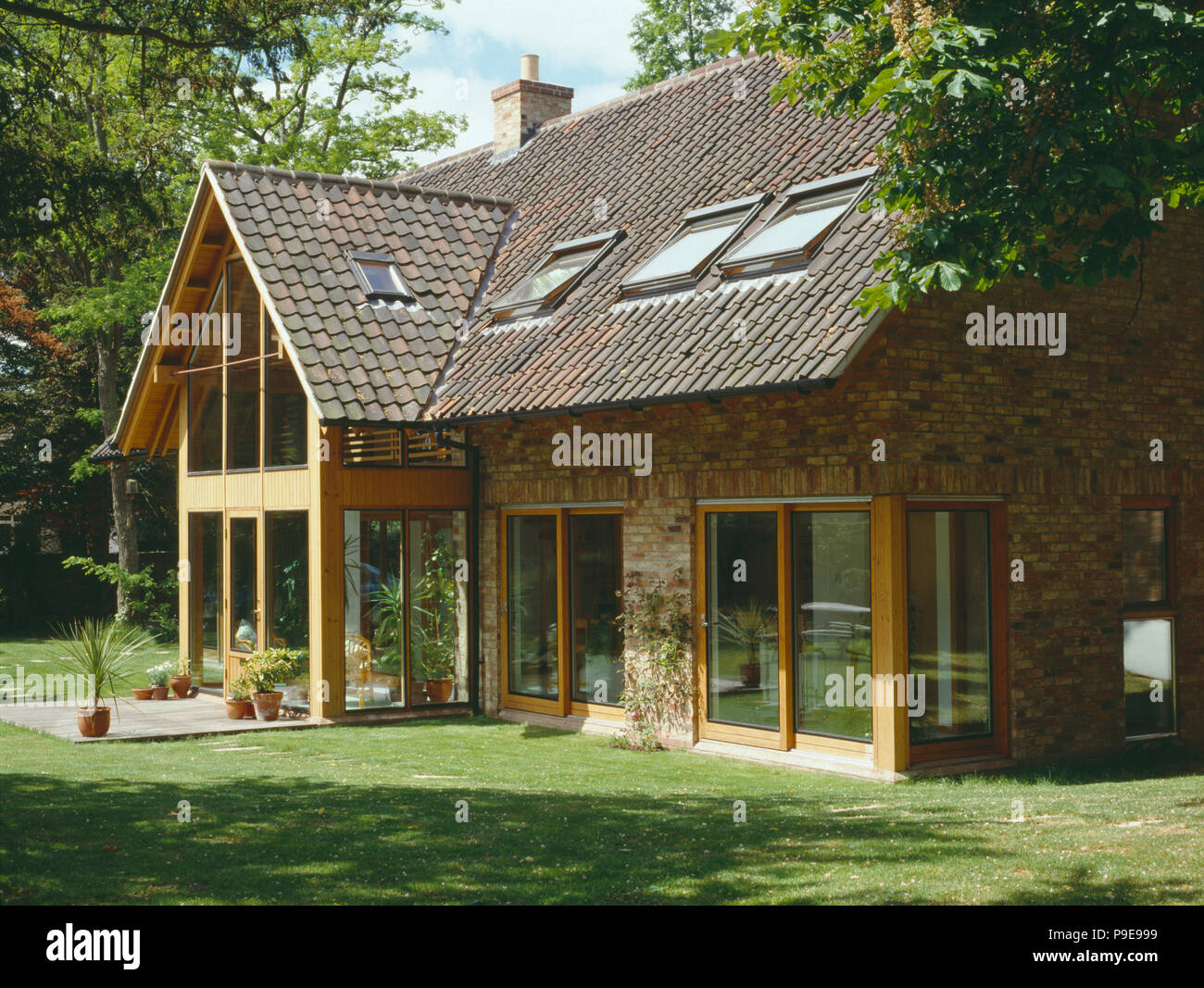 velux windows and sliding glass doors on modern country house with reclaimed pantiles Stock Photo