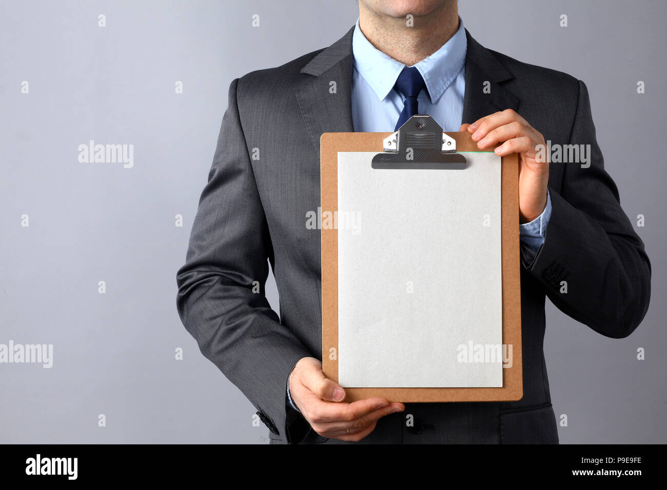 Young man standing with folder, isolated on gray background Stock Photo
