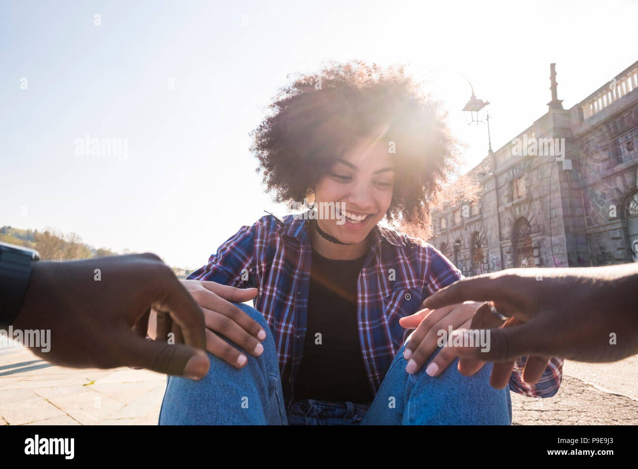 beautiful nice black race ethnic hair gyoung girl have fun with a african man smiling and laughing with him. happy people at the city. backlight and s Stock Photo