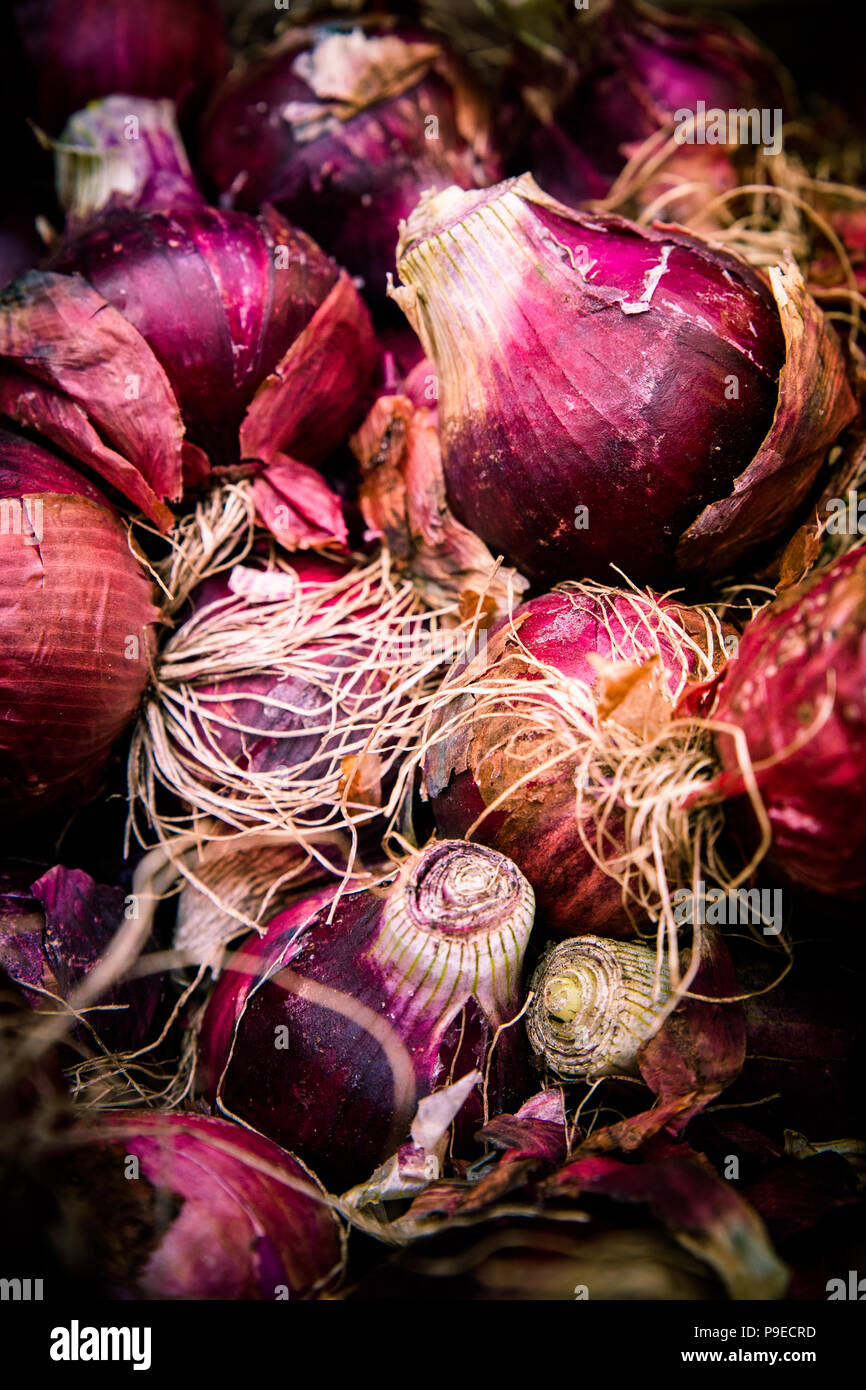 Crop of raw red Bermuda onions at farmers market Stock Photo