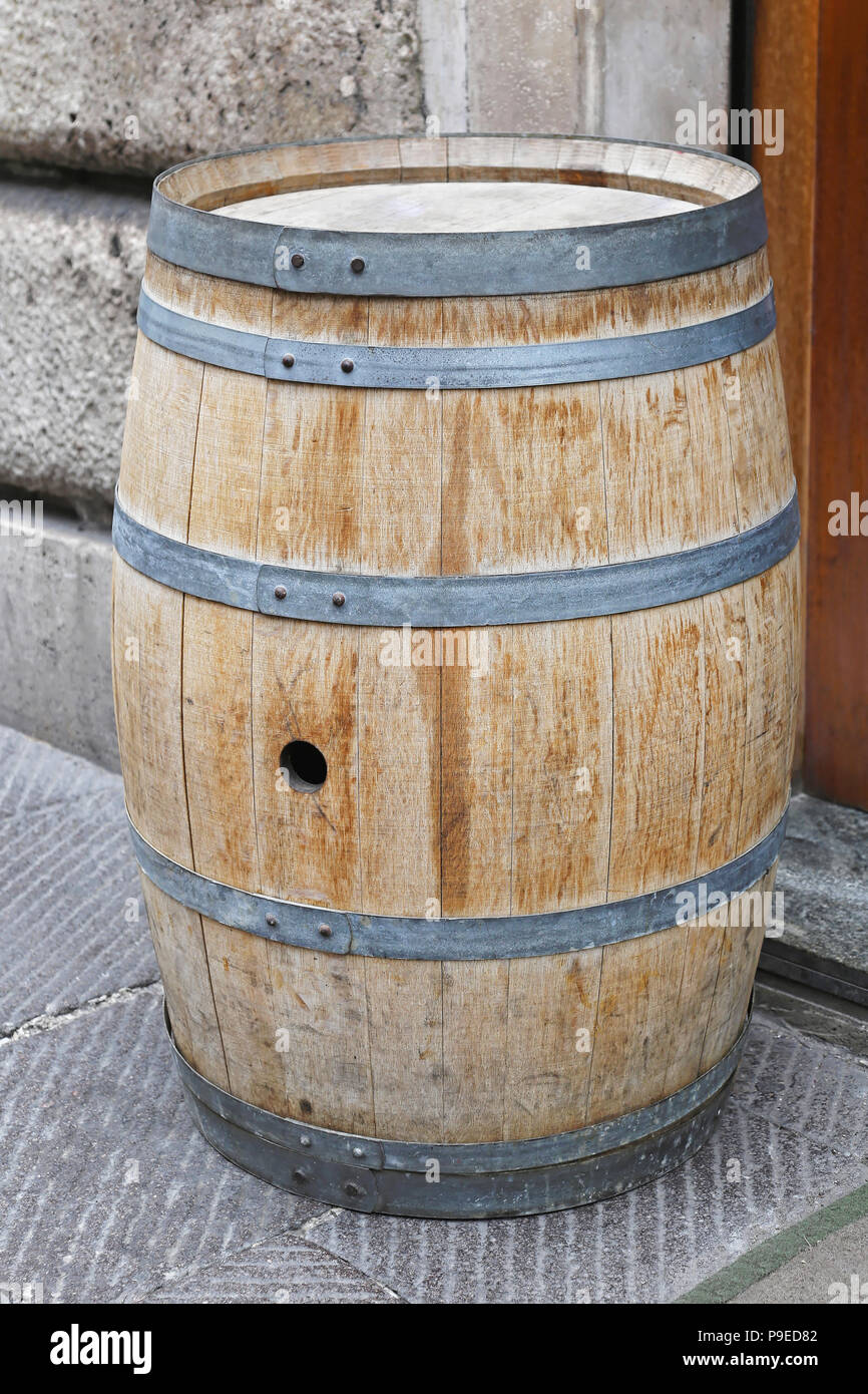 Traditional vine barrel made from oak wood with metal hoops Stock Photo