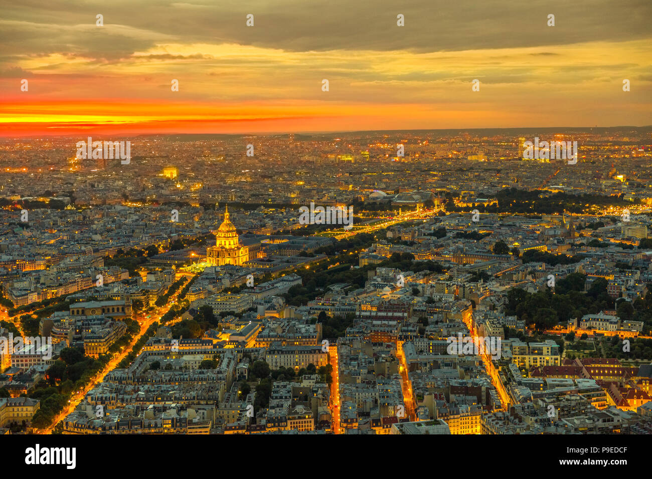 Paris urban skyline cityscape. Aerial view of national residence of the Invalids palace on orange sunset with night street light from panoramic terrace of Tour Montparnasse. European capital of France Stock Photo