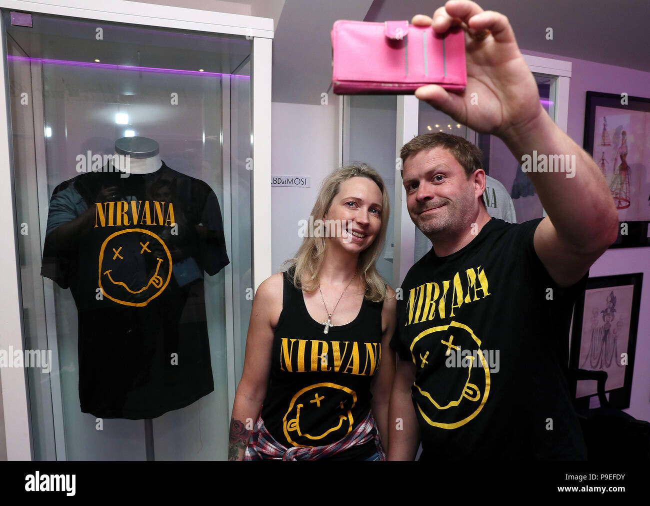 Nirvana fans Tanya and Dave Deegan, from Dublin, take a picture alongside  Kurt Cobain's Nirvana smiley face t-shirt at the opening of the 'Growing Up  Kurt' exhibition on the life of the