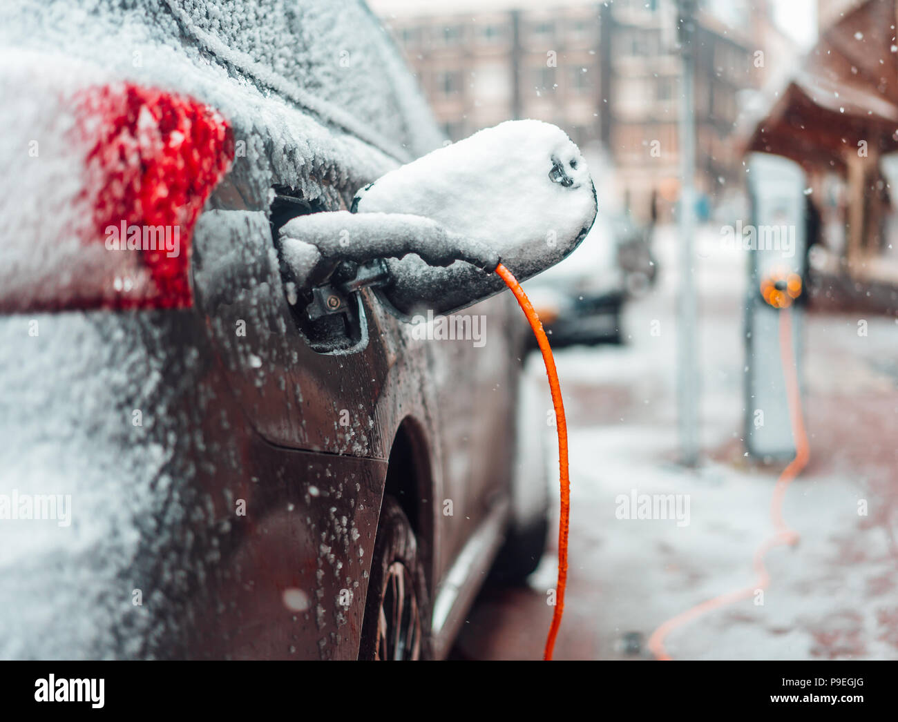 Electric car plug charging in the winter Stock Photo Alamy