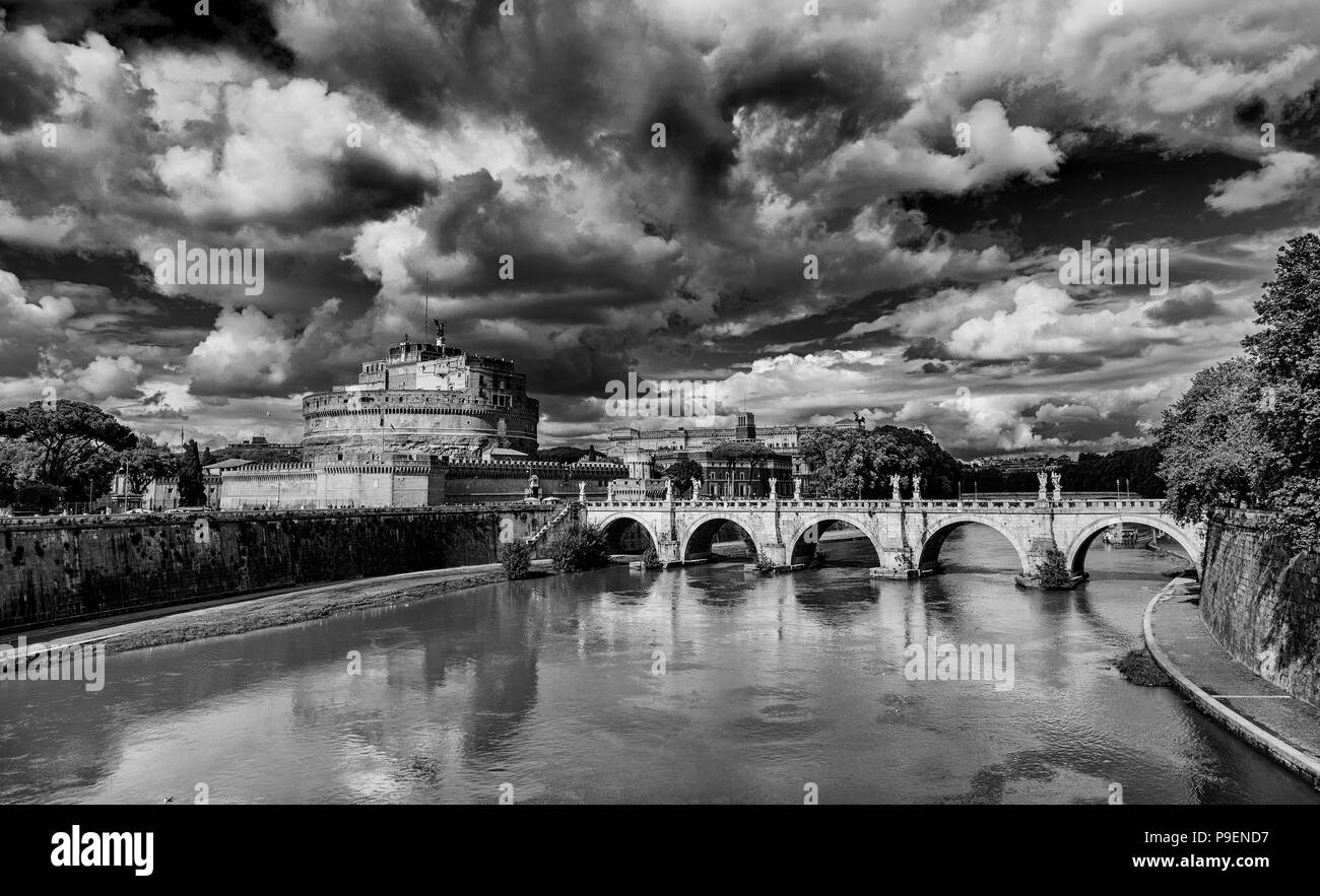 Panoramic view of River Tiber with the Holy Angel Castle and Bridge under a cloudy sky in Rome (Black and White) Stock Photo