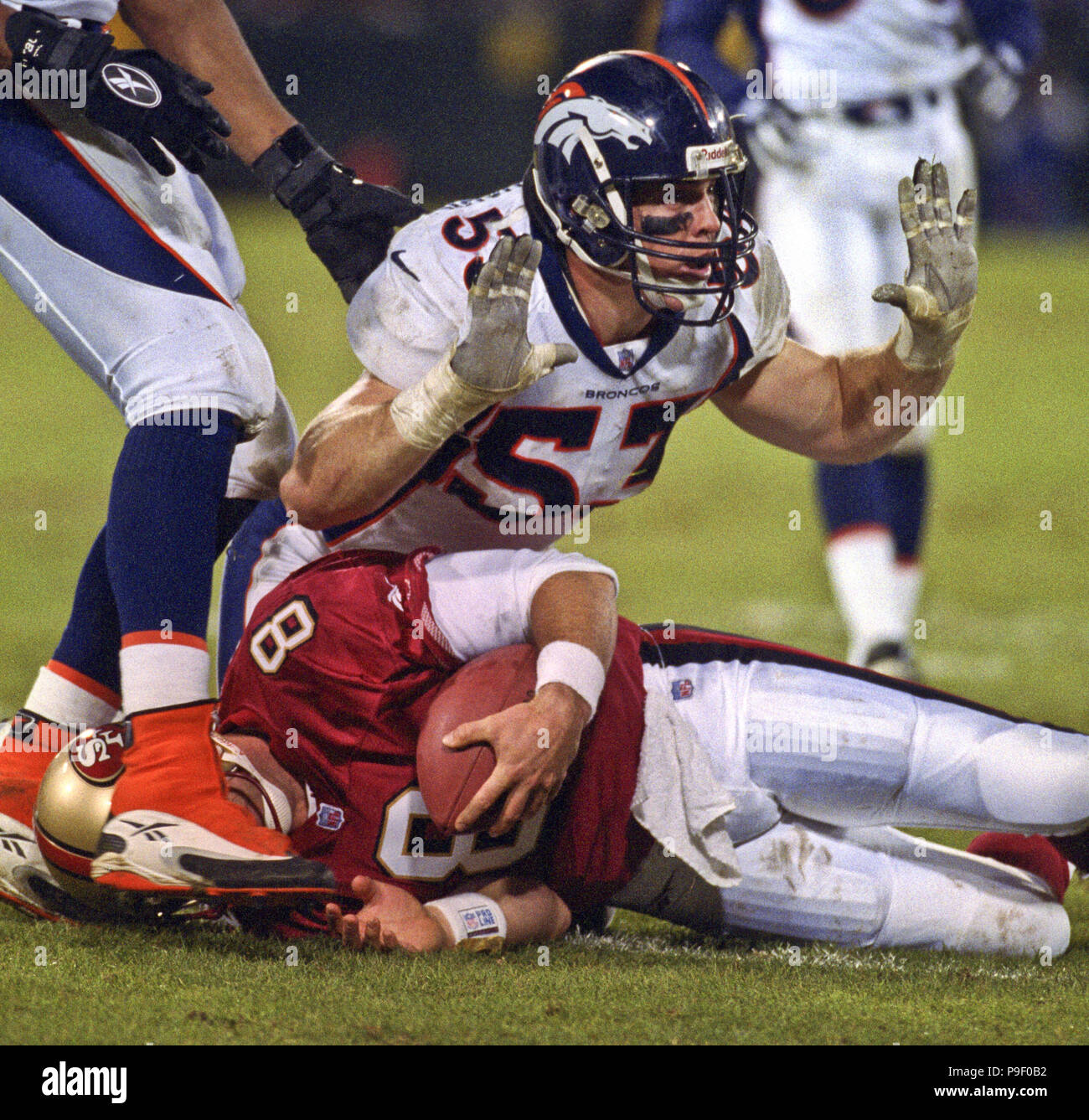 San Francisco, California, USA. 15th Dec, 1997. San Francisco 49ers vs. Denver Broncos at Candlestick Park Monday, December 15, 1997. 49ers beat Broncos 34-17. Denver Broncos linebacker Bill Romanowski (53) hits San Francisco 49ers quarterback Steve Young (8) on the ground. Credit: Al Golub/ZUMA Wire/Alamy Live News Stock Photo