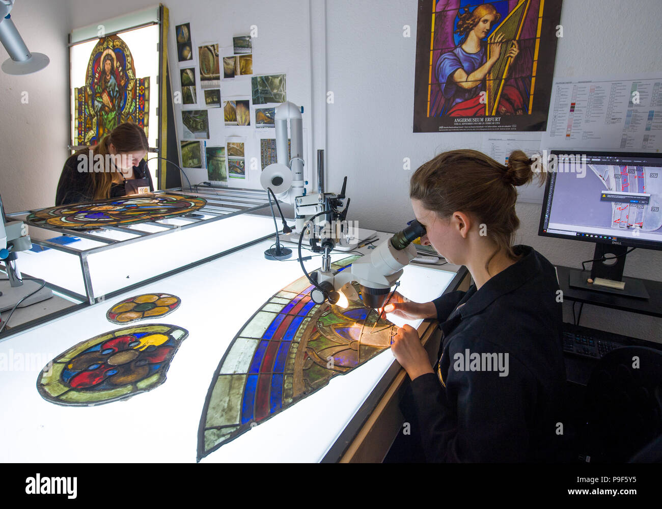 28 July 2018, Naumburg, Germany: Caroline Vogel, intern of the University of York and Jana Hildebrandt (L), conservator work at the glass-conservation studios of the Naumburg cathedral. The windows are part of the precious artifacts from the mid-13th century owned by the church. The windows have been restored and secured preventively by experts since December. The beginning of October will see the finishing touches on the first window, as well as its placement into the window frames. The Naumburg cathedral boasts countless glassworks unlike any other from the 13th, 14th and 15th century. Photo Stock Photo