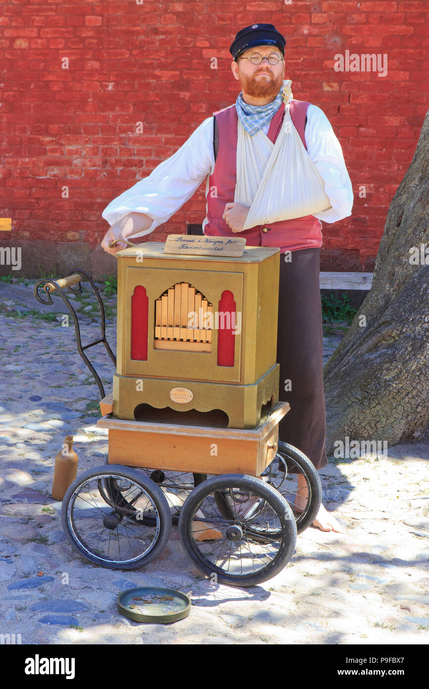 An organ grinder playing his street organ at the open-air town museum